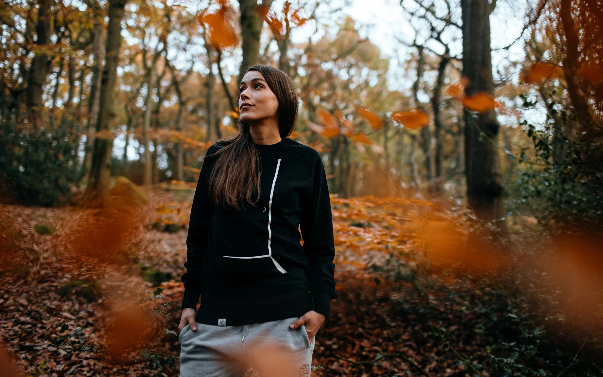  female model stands in Alton woods in tomoto jumper