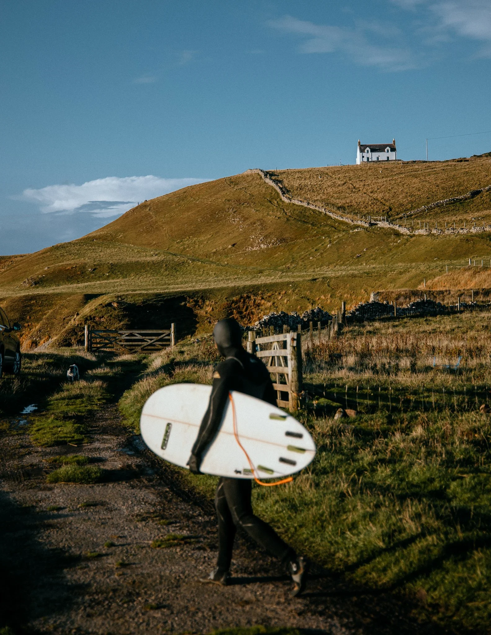  surfer heads towards the beach, north coast of Scotland