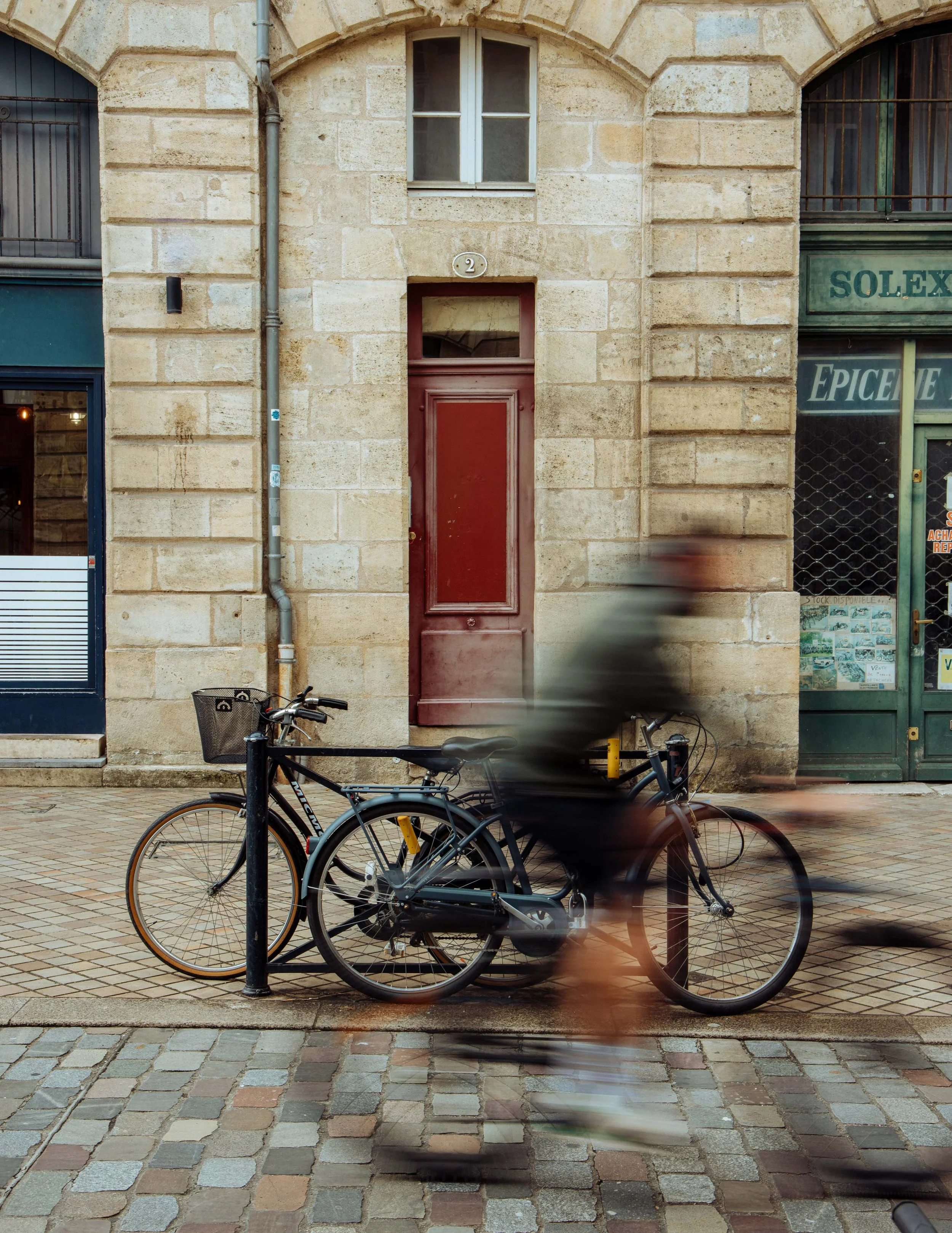  a cyclist cycles past bikes, in Bordeaux, France