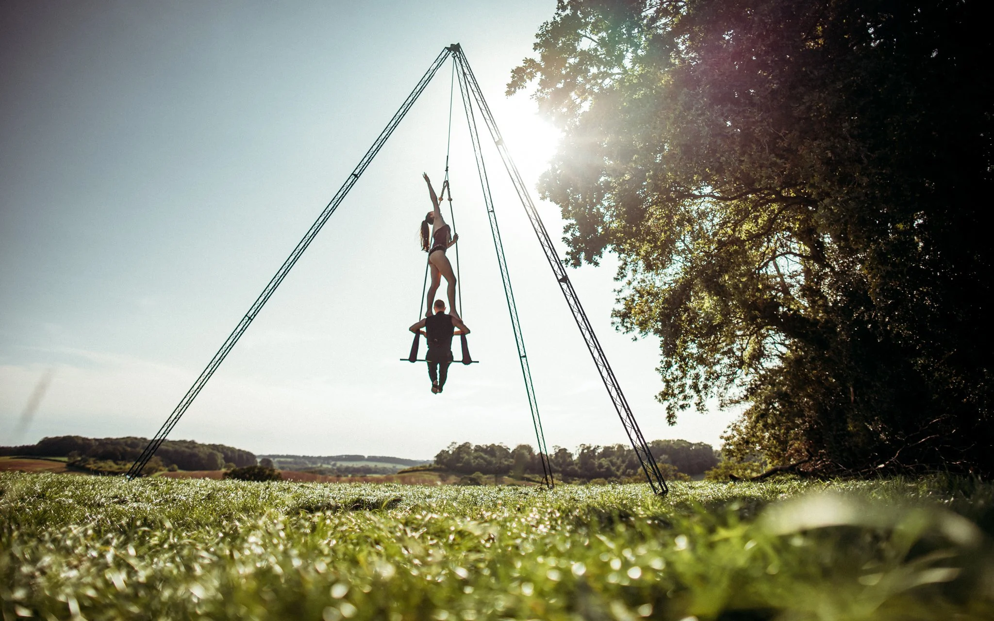 Couple on trapeze in sunset