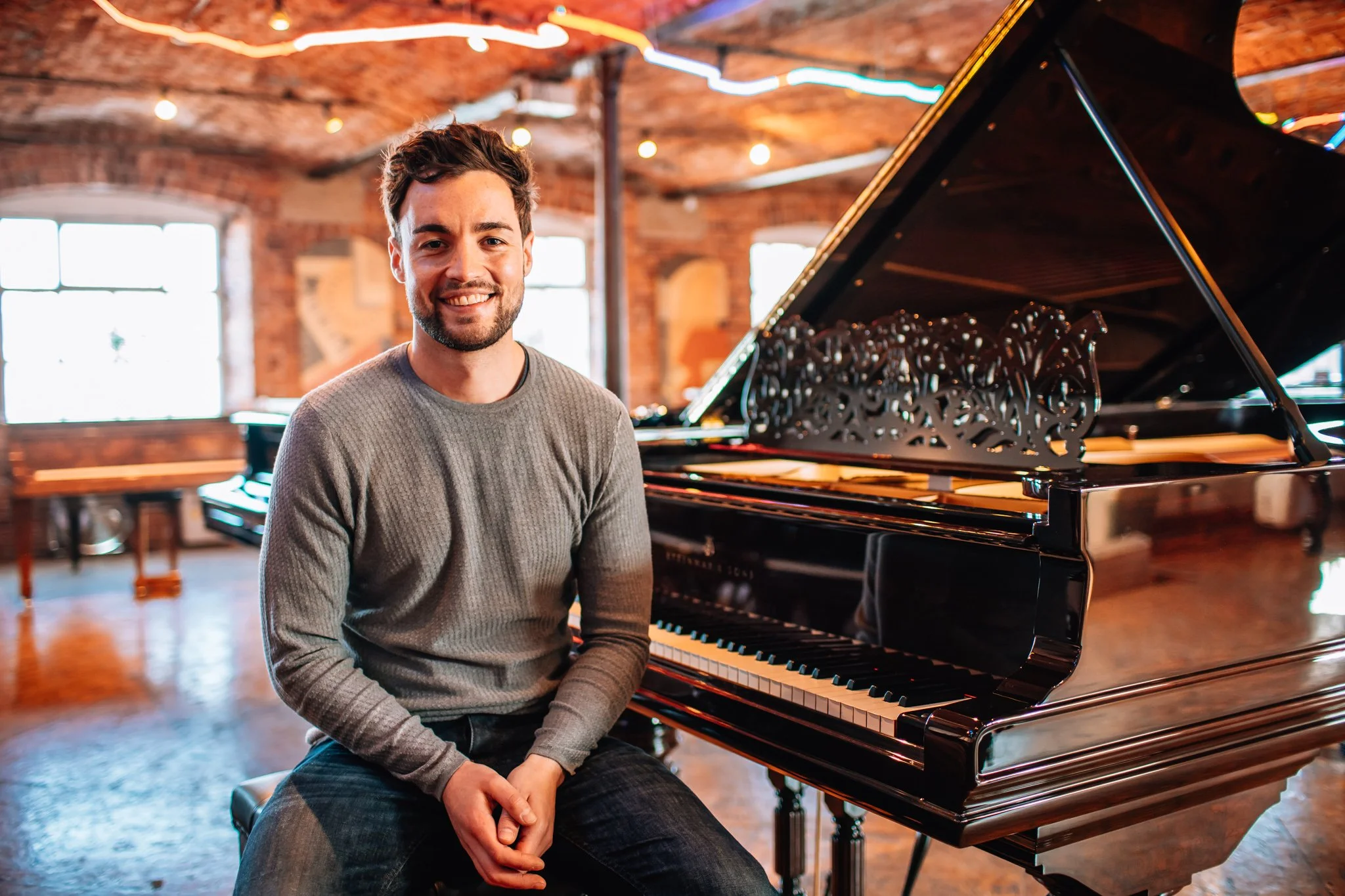 Man poses for portrait, piano