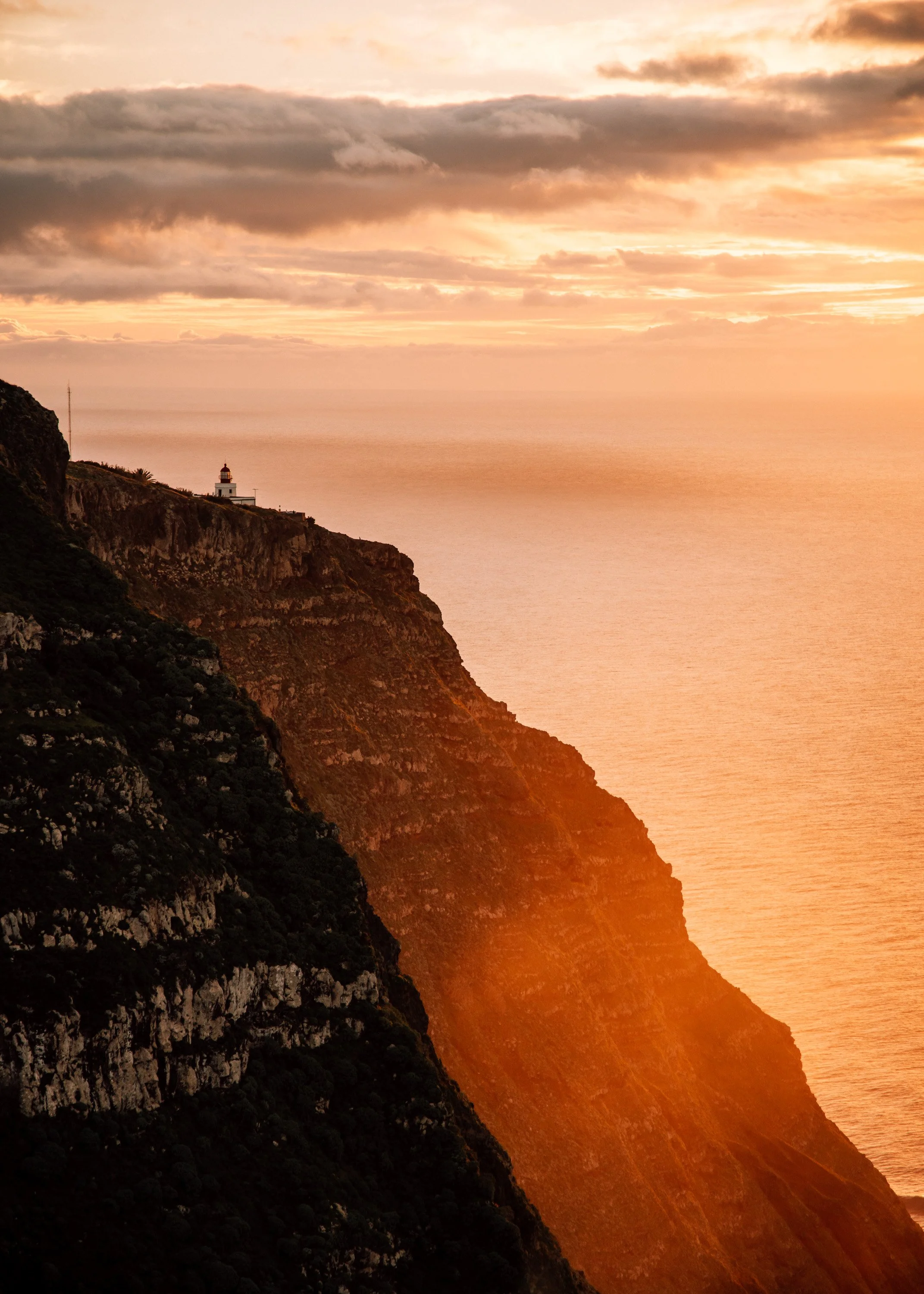  sunset behind a lighthouse on the cliffs Madeira