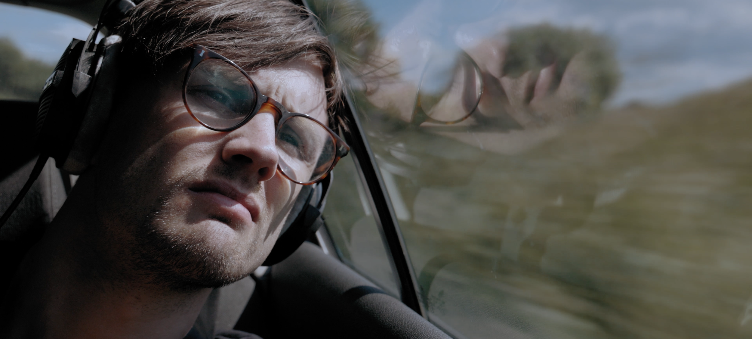 Twogood Music video Garry fingerloaf sits in car, looking upset