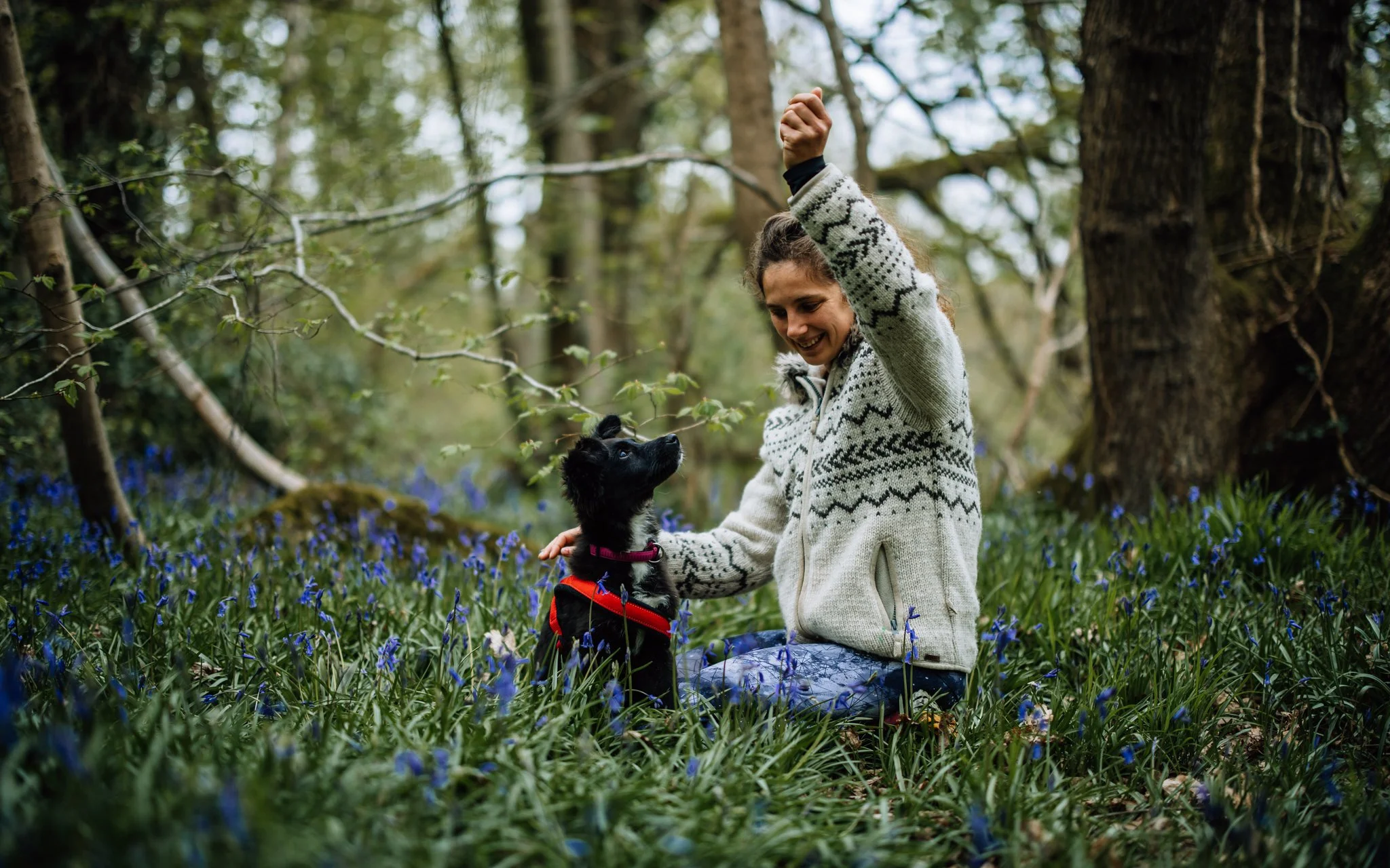  girl and dog sit amongst bluebells