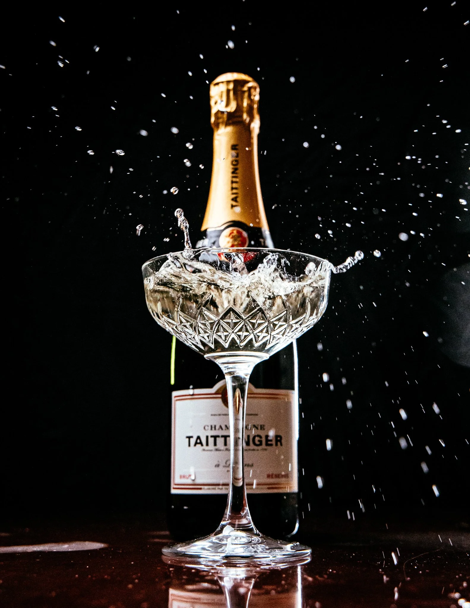  a cork splashes into a glass of champagne