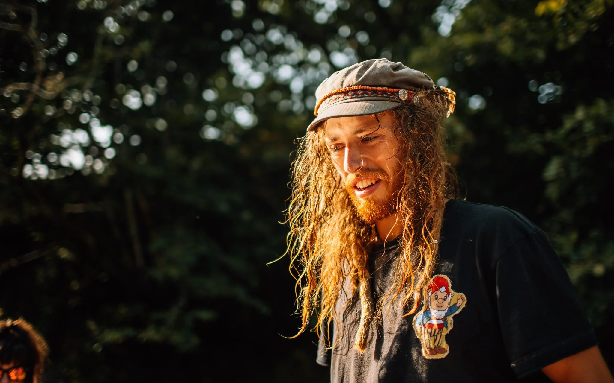 A man with long hair stands in the sunset