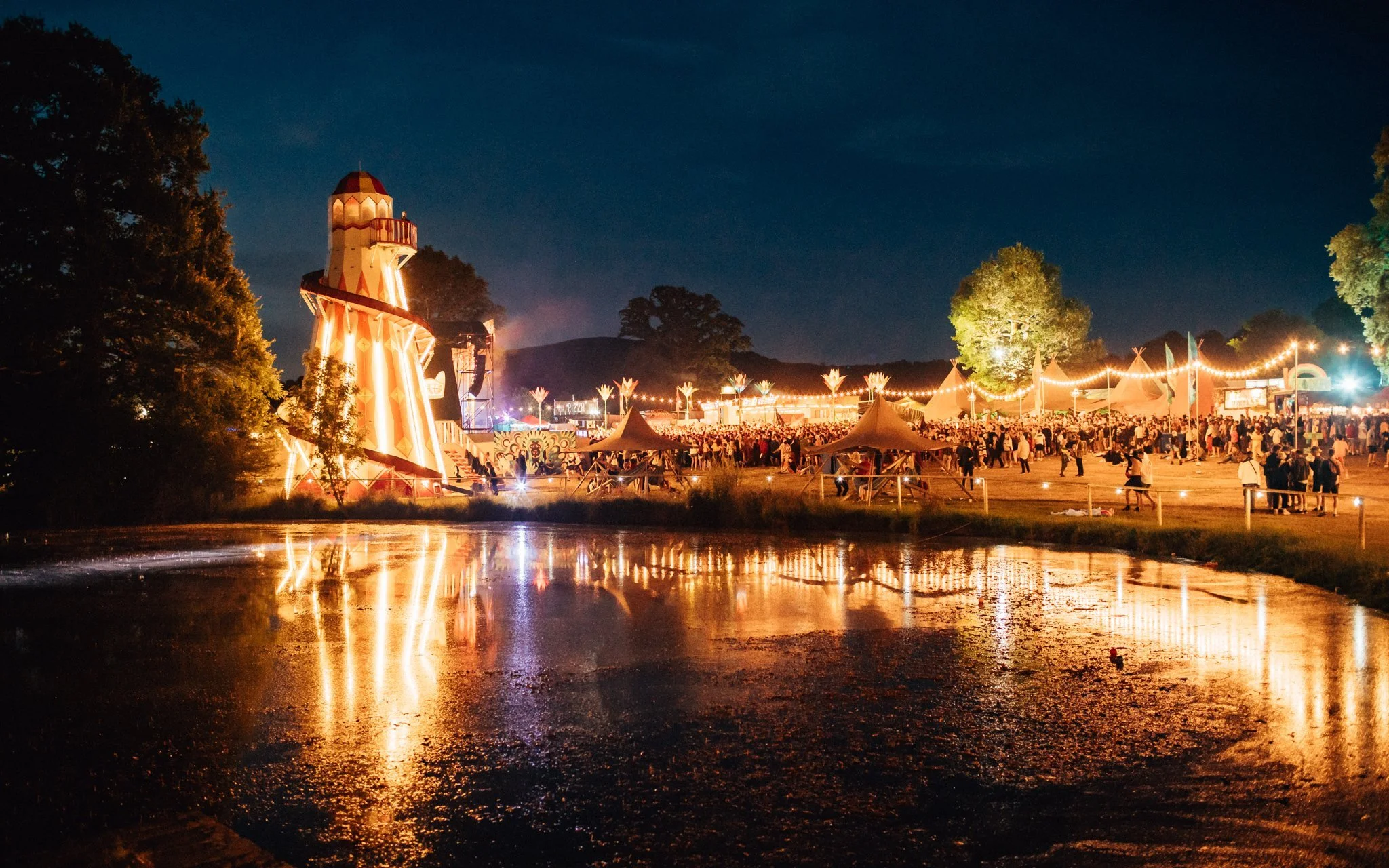 A lake and fairground ride at a music festival