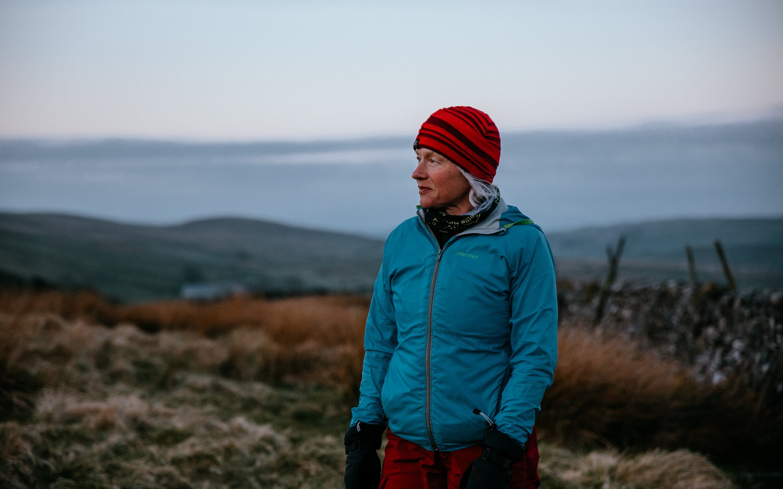 Adventure photography, early morning woman looks at sunrise