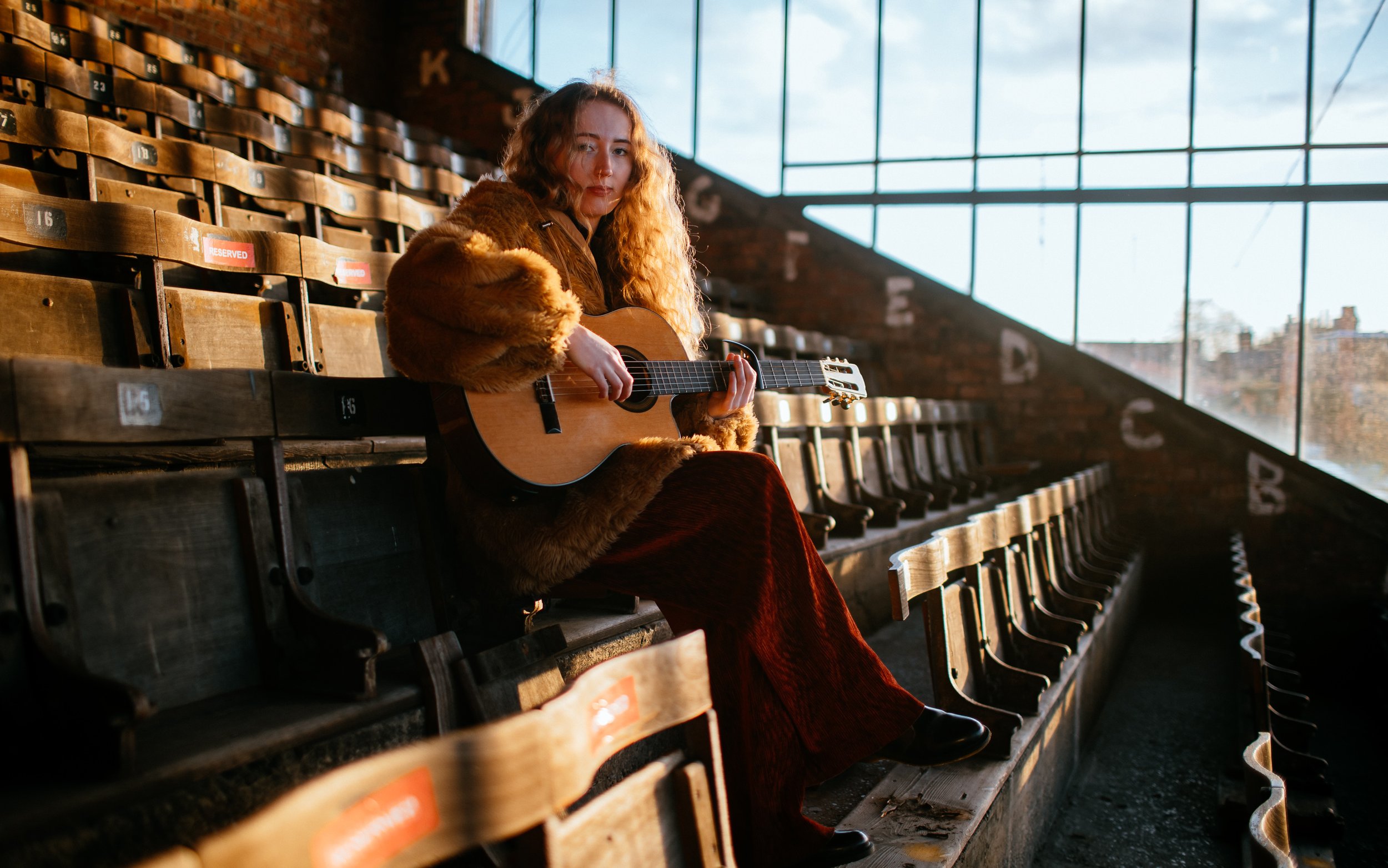  girl, sits at Bootham Crescent with guitar