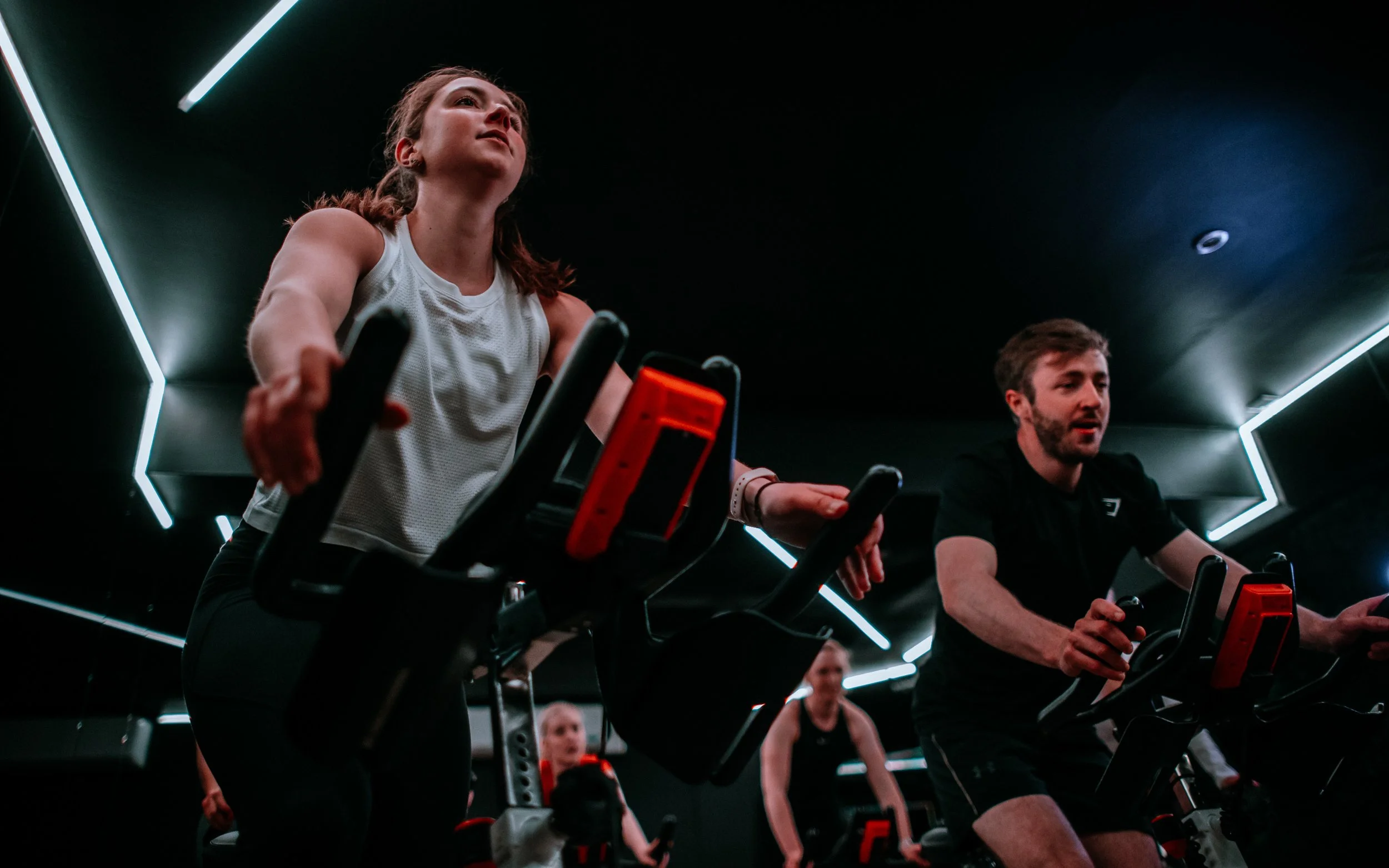  man, and woman on spinning machines at North Studio Leeds