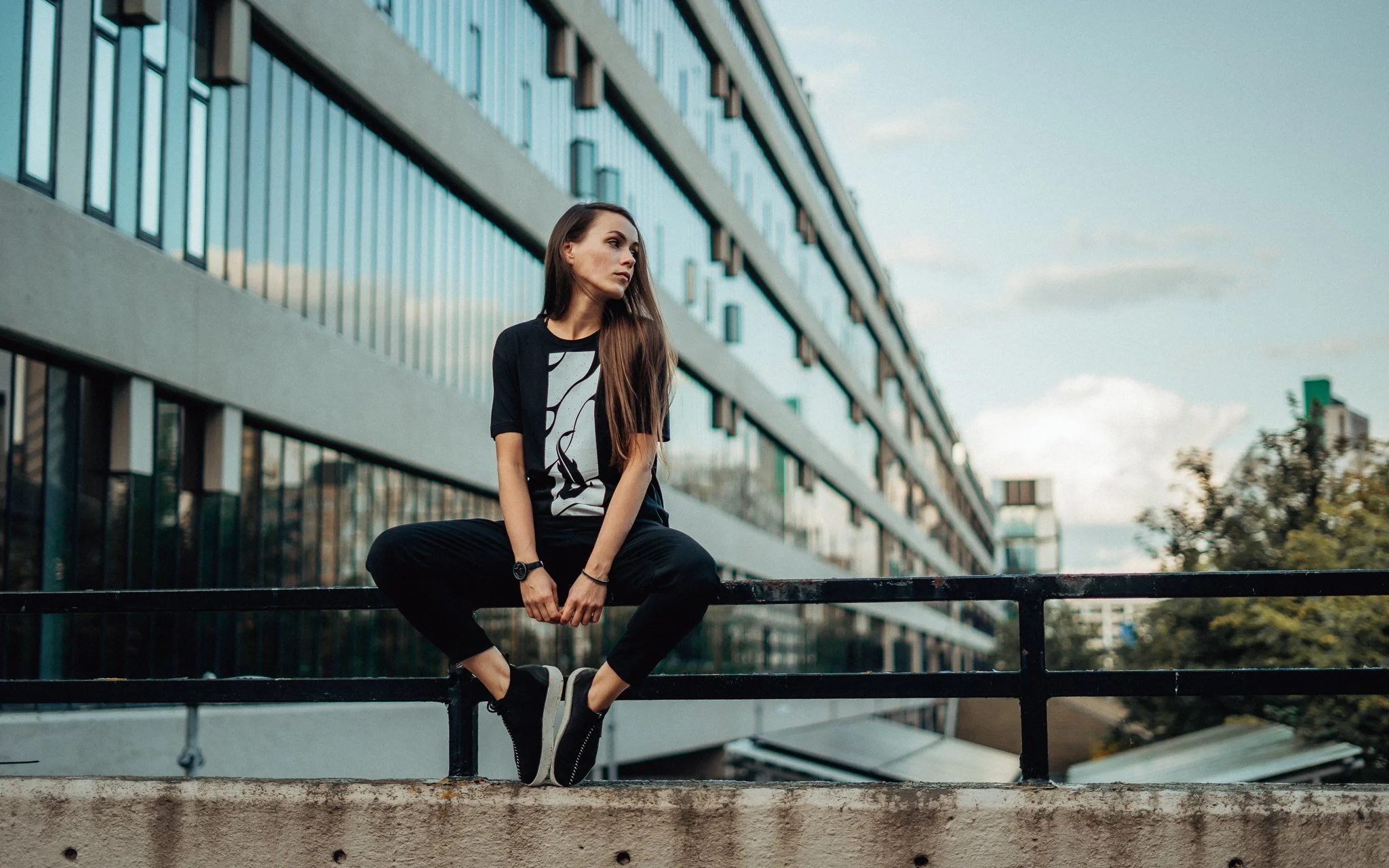  girl sits on the fence modern building