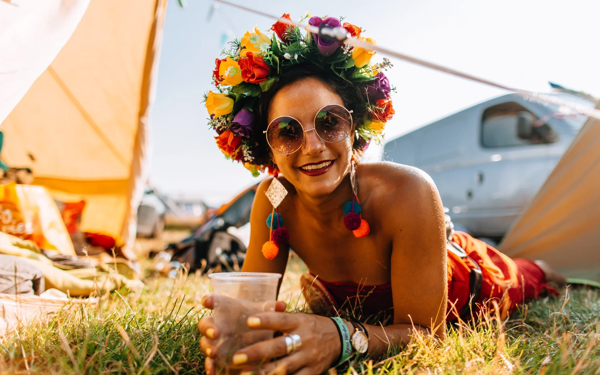 Girl with beautiful flower, garland, relaxing in the Sun at music festival