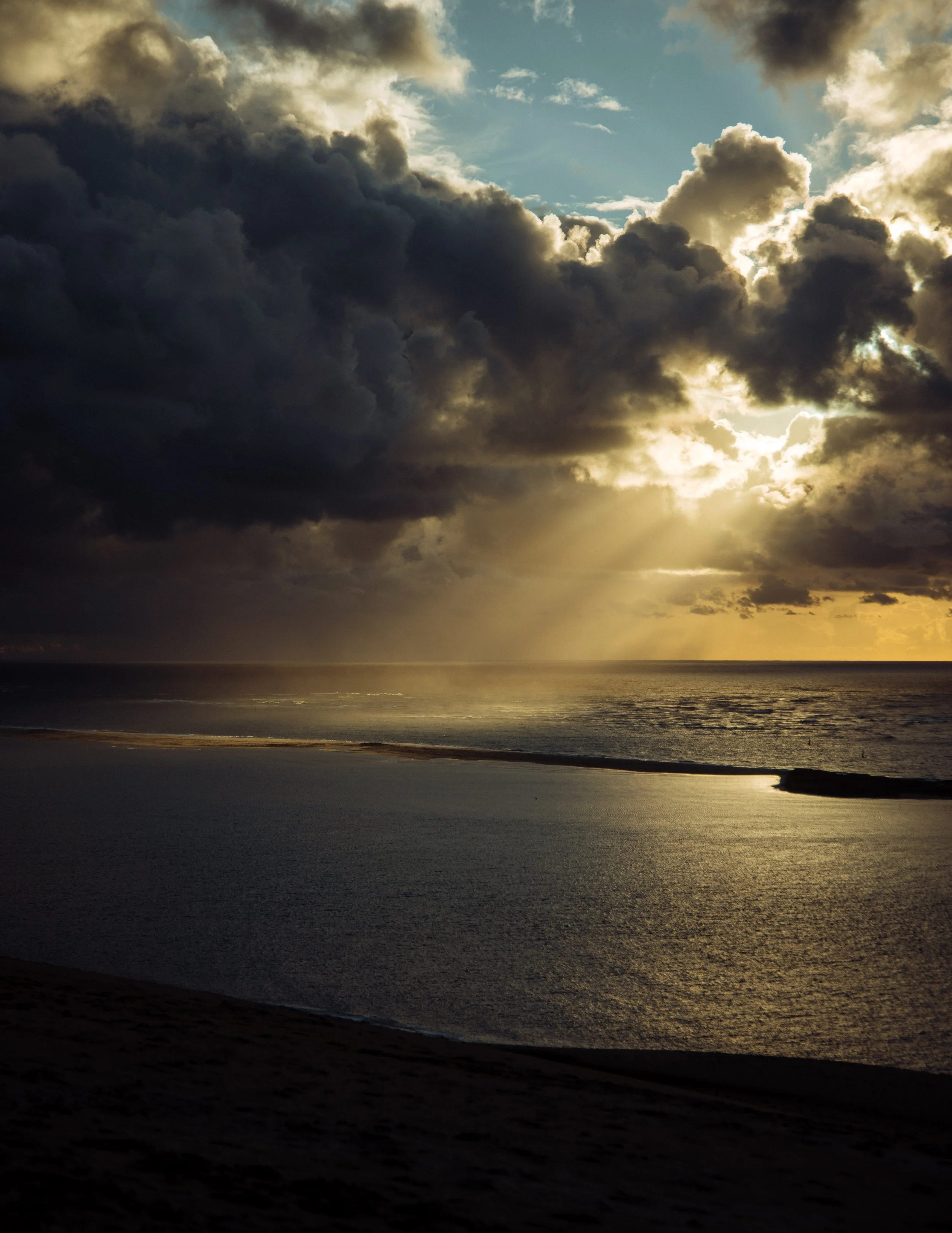  sunlight stream through a cloud above the French coast