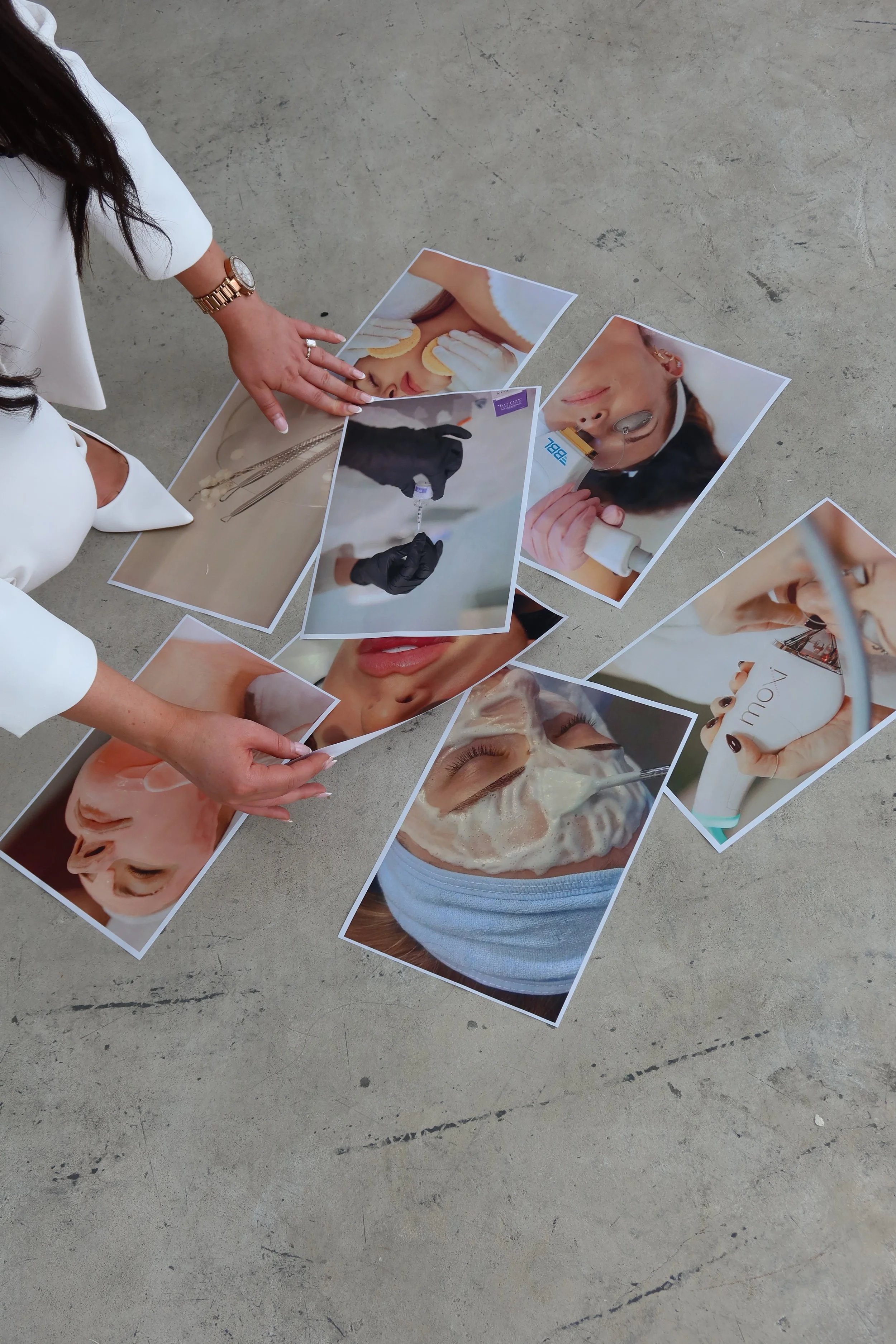 Hands arranging printed photos of skincare and facial treatment procedures on the floor.