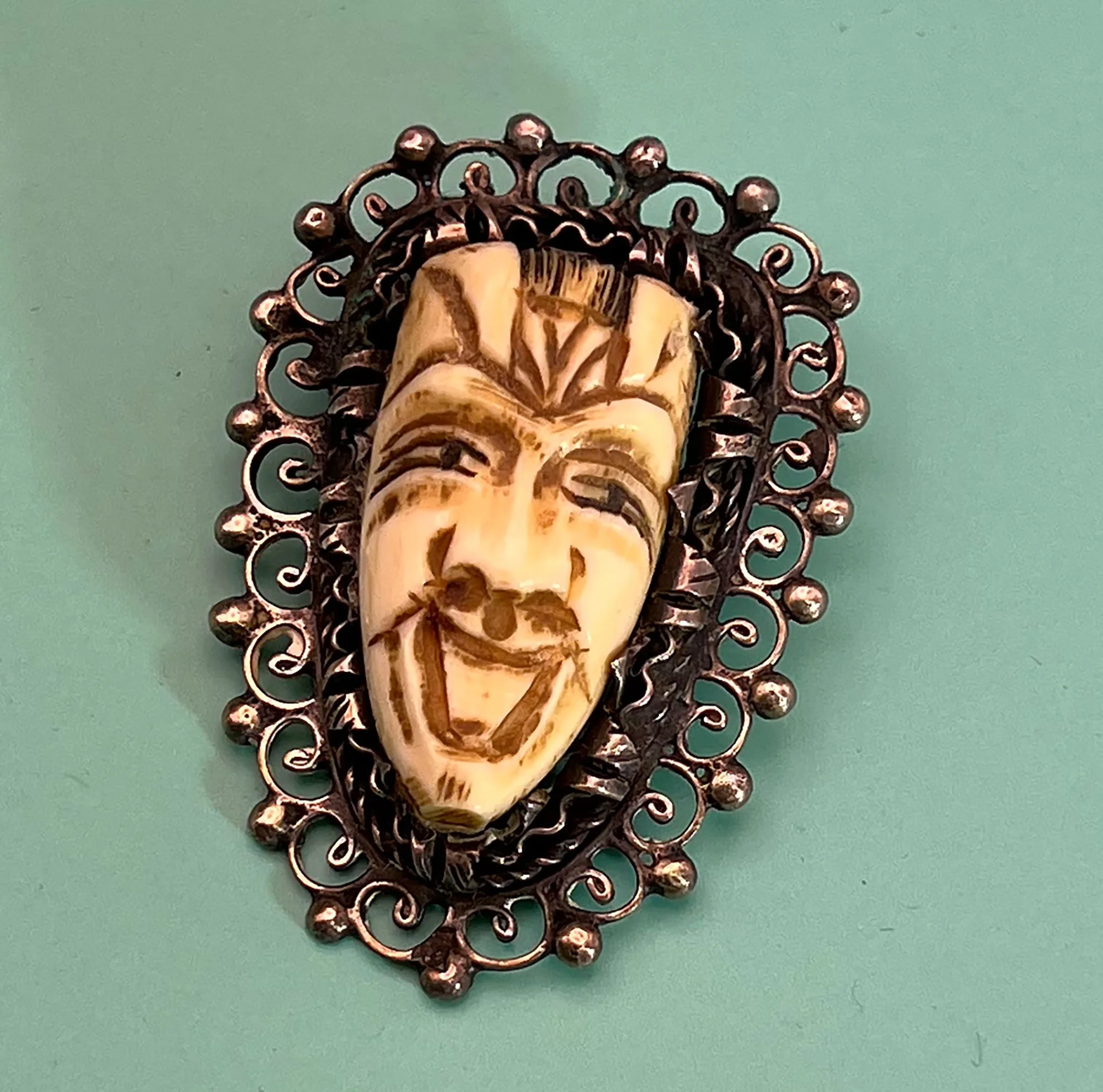 Carved bone and silver brooch