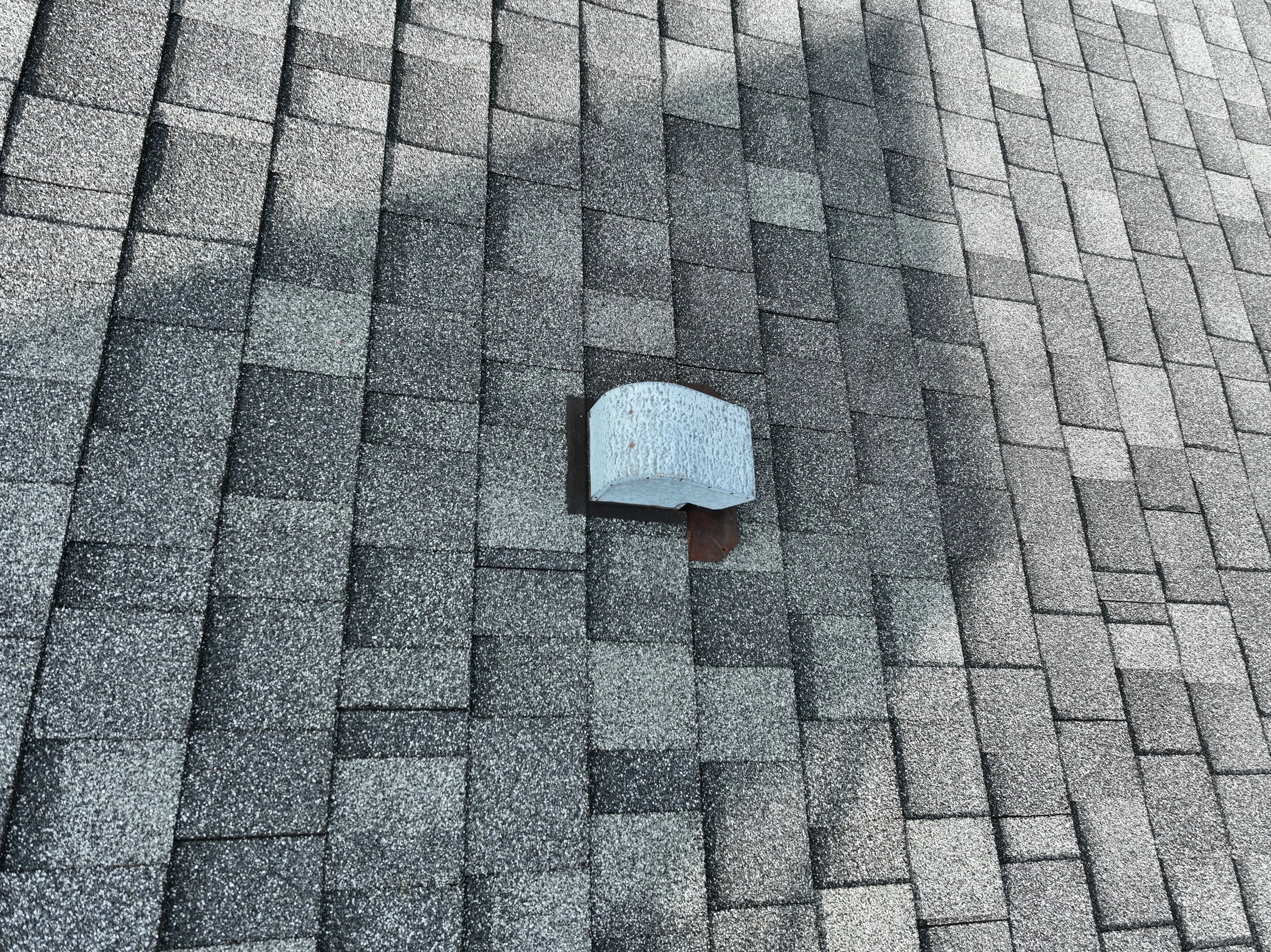 Gray asphalt shingle roof with a small vent pipe poking through.