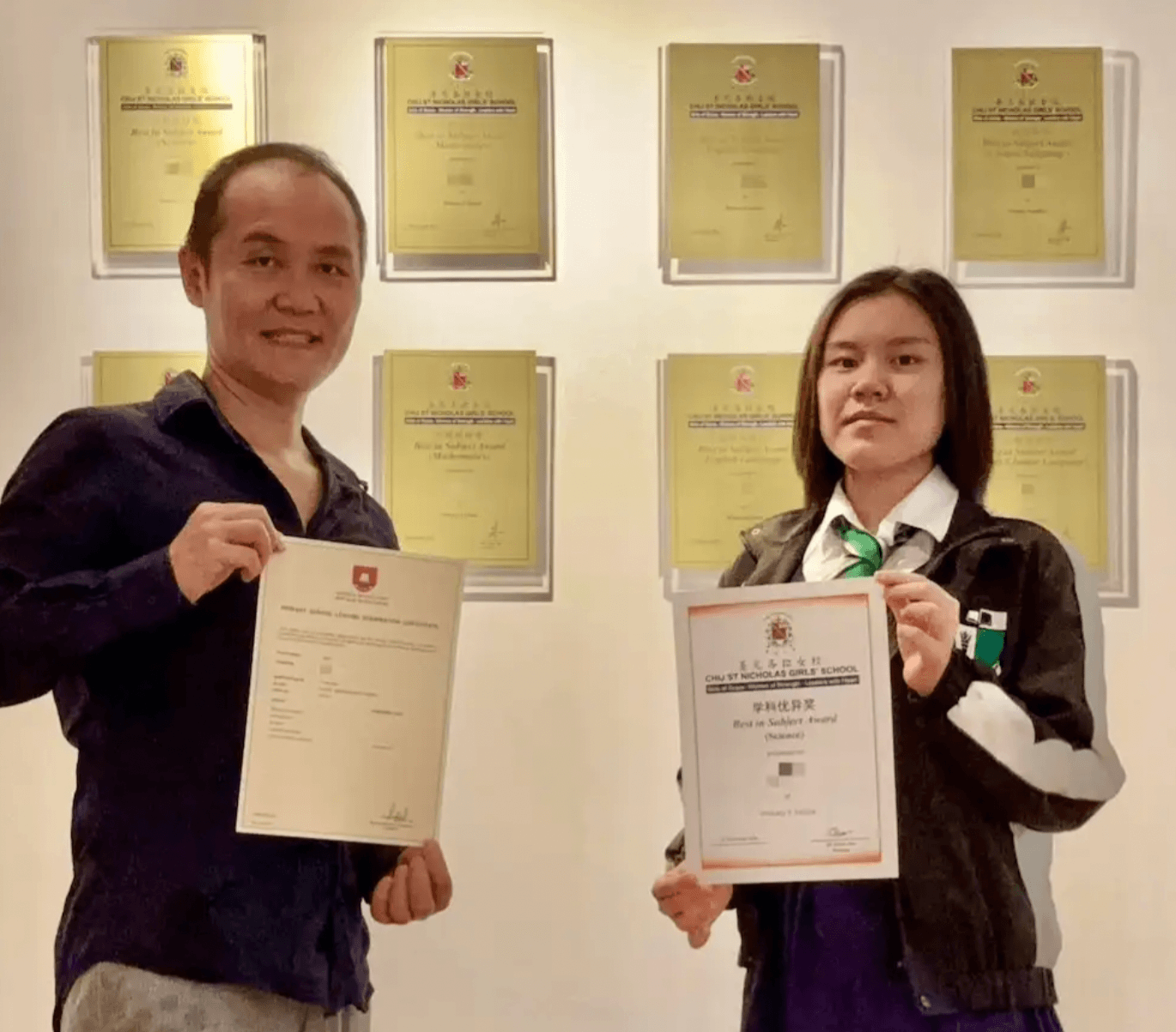 Super Tutor Nelson Leow (M.Eng.) with CHIJ St. Nicholas Girls' School (SNGS) student at an award wall displaying Best in Math, Best in Science, Best in English, and Higher Chinese awards won in P4 (2023), P5 (2024) & P6 (2025) at F9 TO A1 ACADEMY