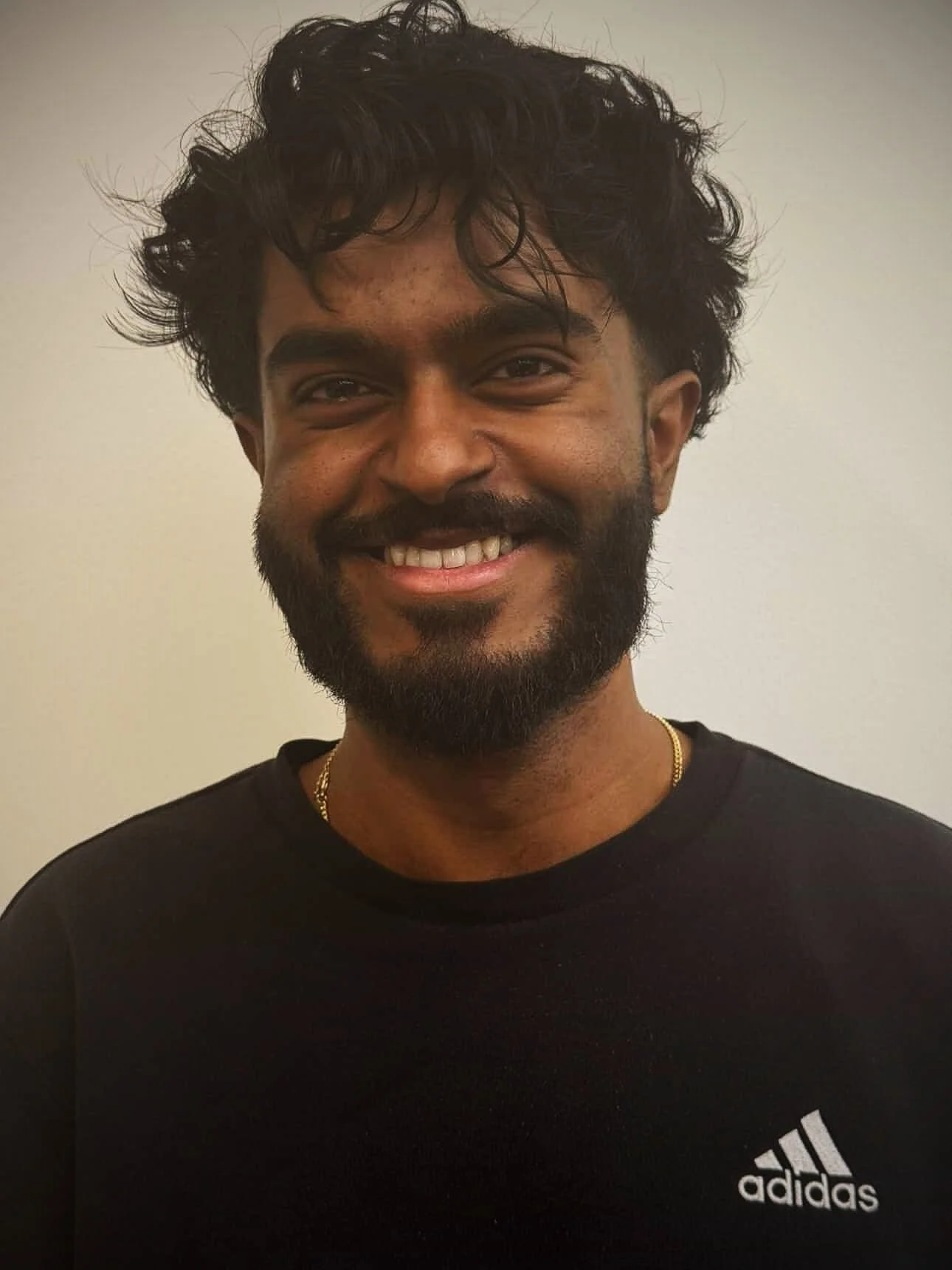 Headshot of Ashwin, AGF volunteer, darker skin toned male with black wavy hair and a short beard.