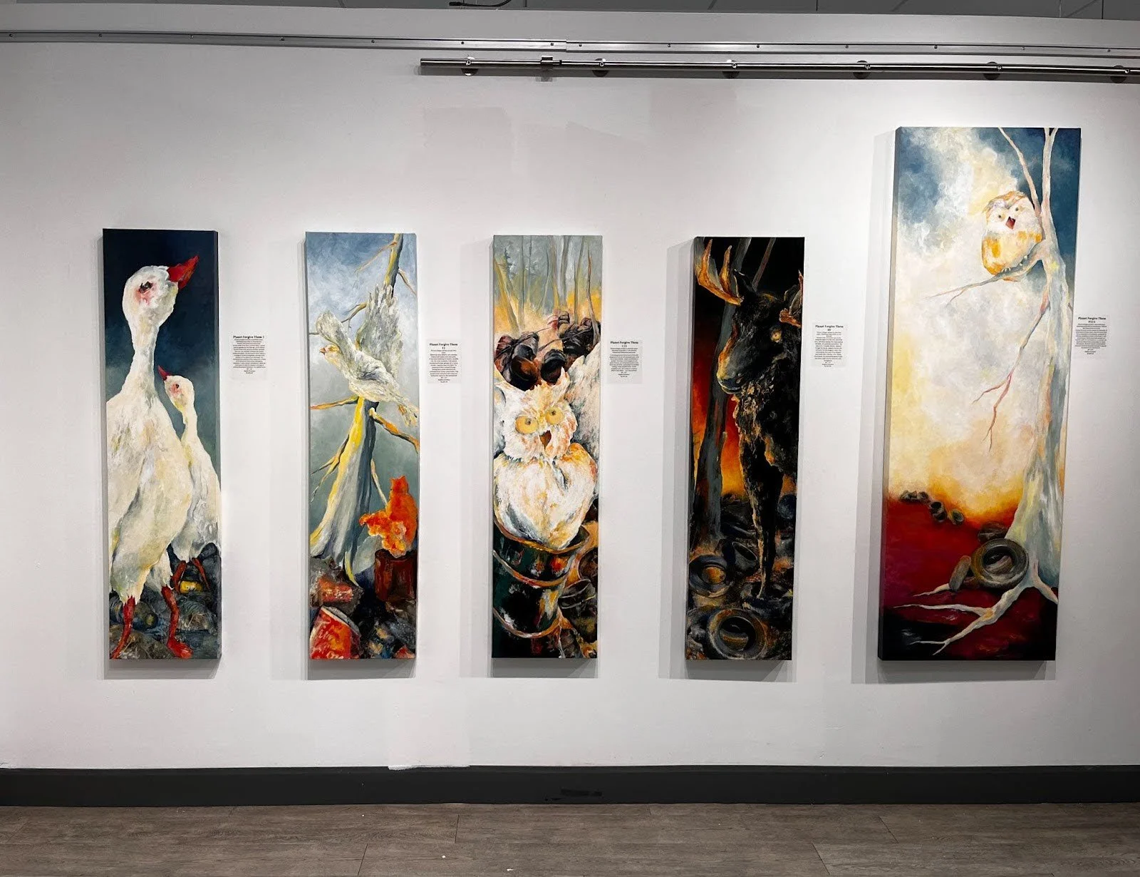 Five vertical mixed-media paintings by Brigitte Goudreau displayed on a gallery wall, exploring themes of nature, waste, and transformation.
