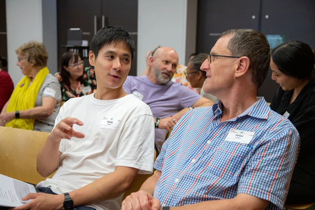 Two male participants discussing during a conference workshop