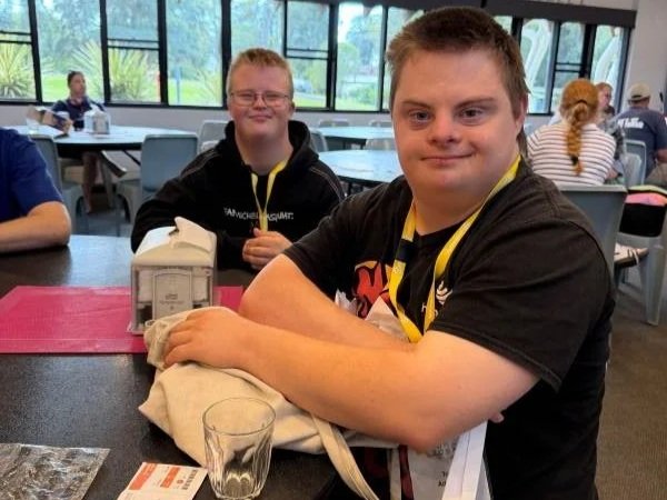Two young men with disability are sitting at a table