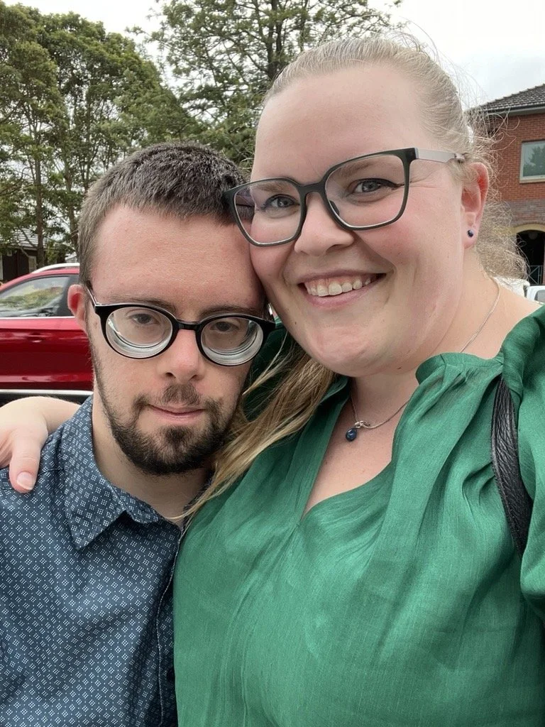 A young man and his older sister both looking at the camera