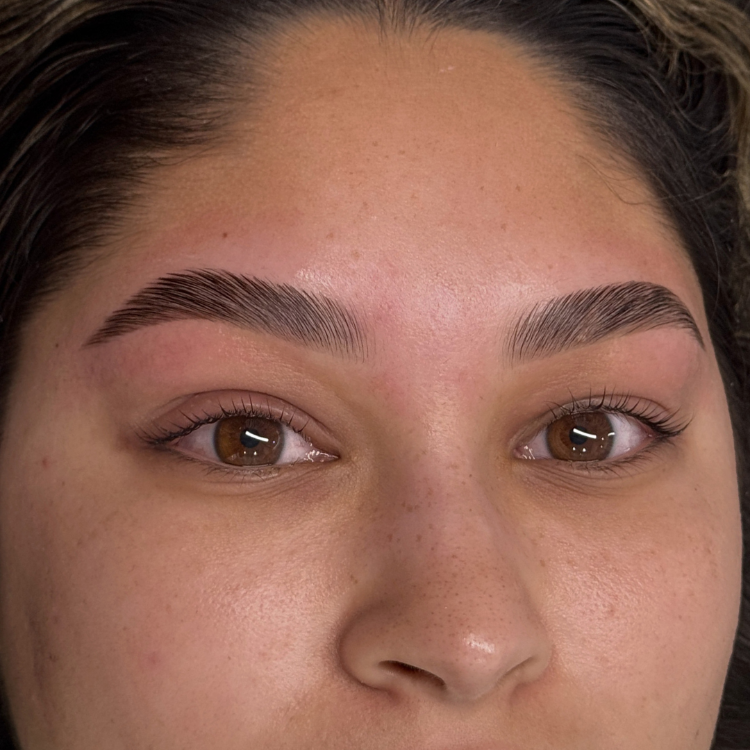 Close-up of a woman's face showing well-groomed eyebrows and brown eyes.