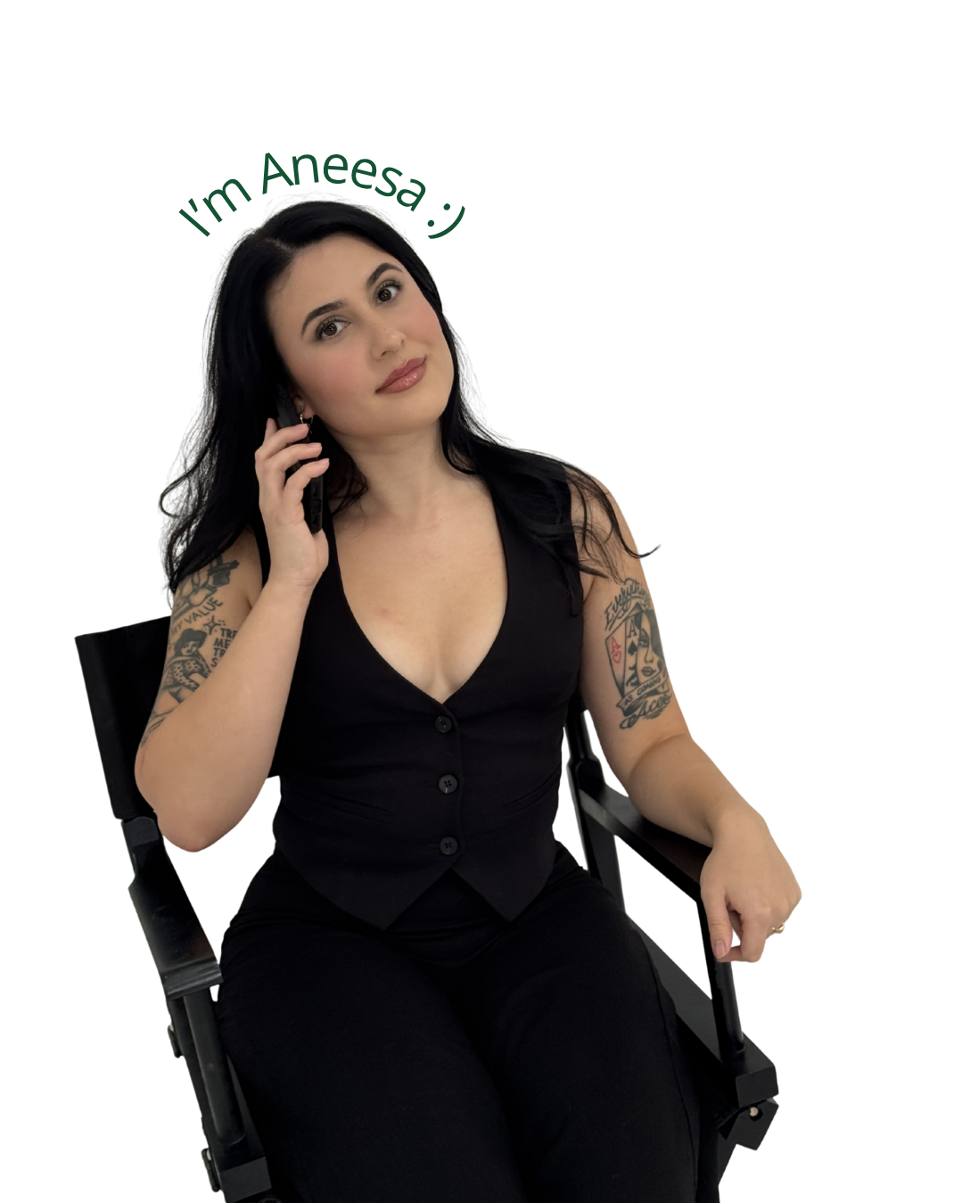 A woman with black hair, wearing a black sleeveless top, sitting in a wheelchair, talking on a cell phone, with tattoos on her arms.