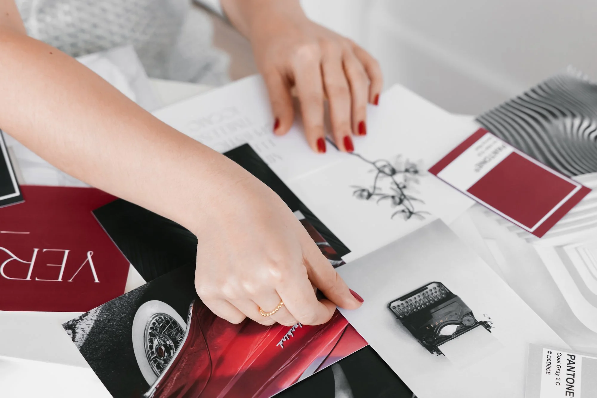 Hands curating brand mood board with printed visuals and color swatches for a branding project