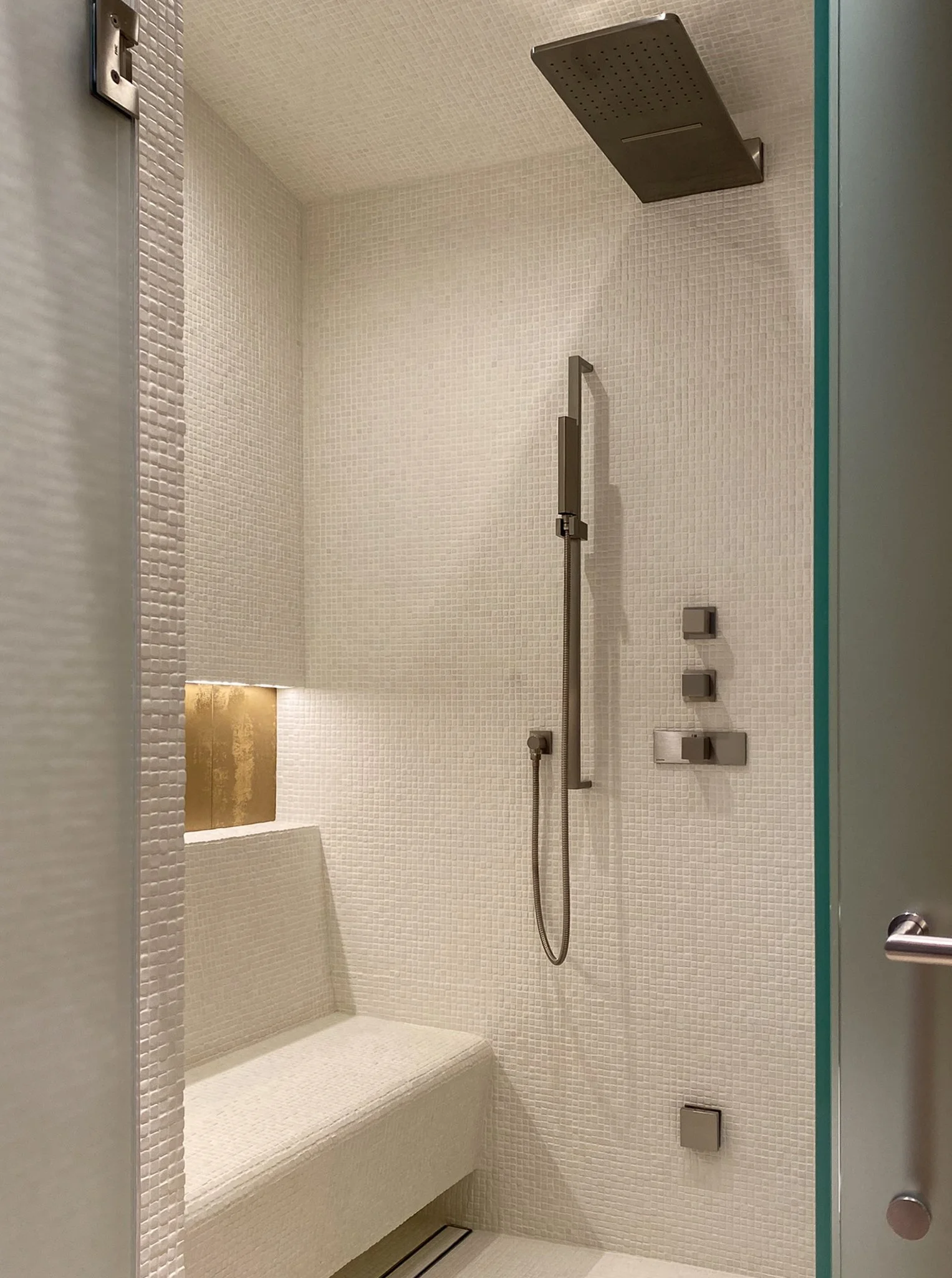 luxury steam shower with soap niche and mosiac tile, integral bench