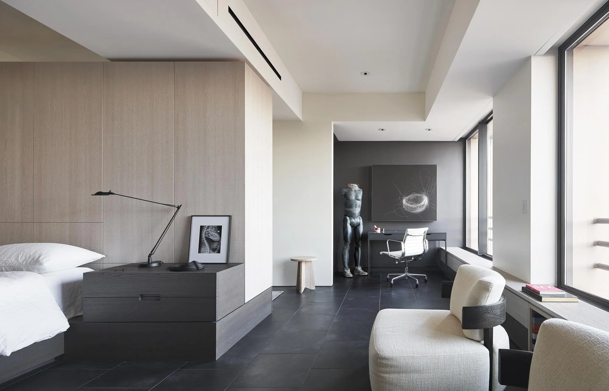 Modern primary suite, custom cabinetry, sitting area, desk and art. Soothing minimal design, monochrome palette