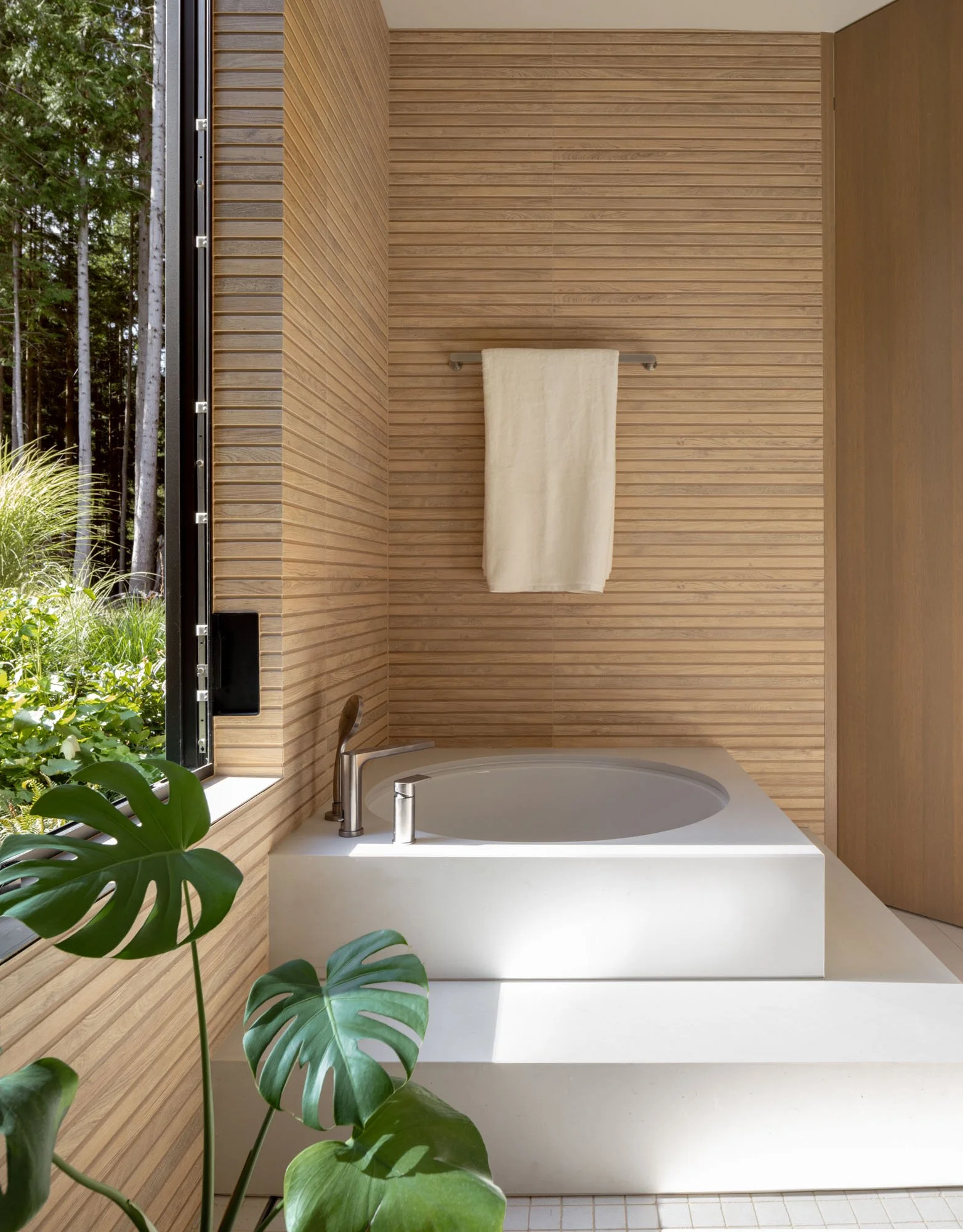 Modern Japanese soaking tub, continous porcelain tile wall finishes