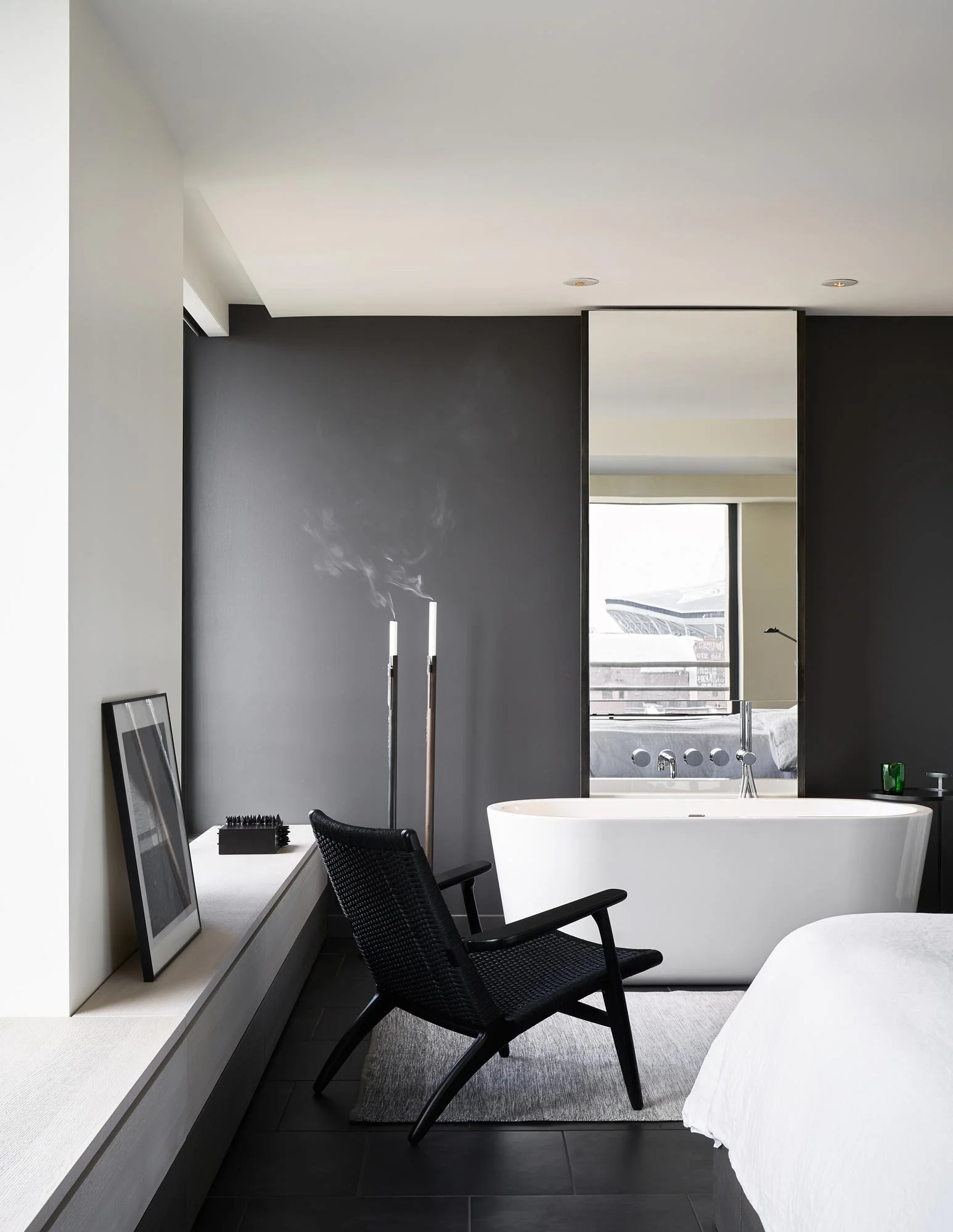 Modern bedroom suite, freestanding tub, Hans Wegner CH25 Easy Chair, monochrome interior design