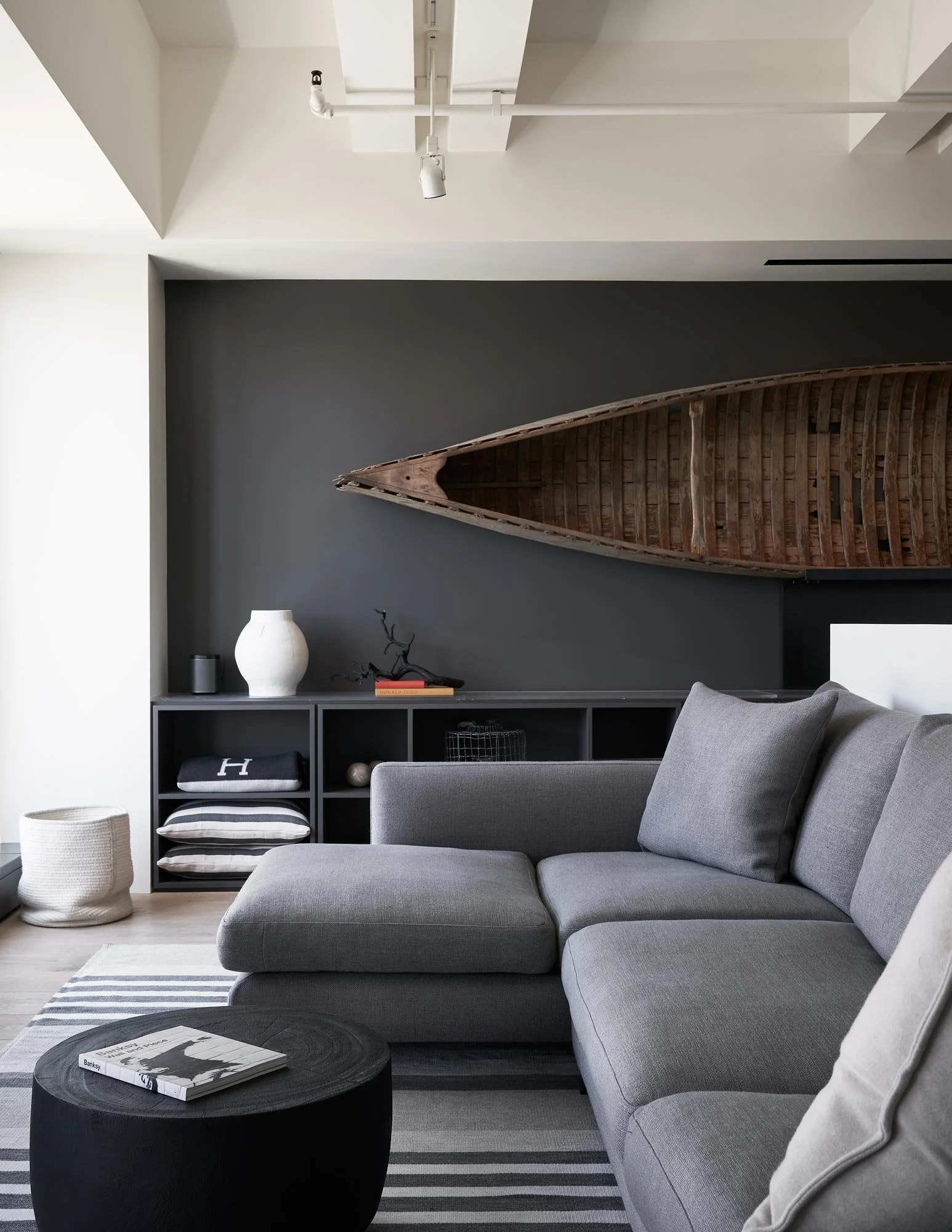 Penthouse living room, antique canoe art, custom area rug, gray and white finish palette