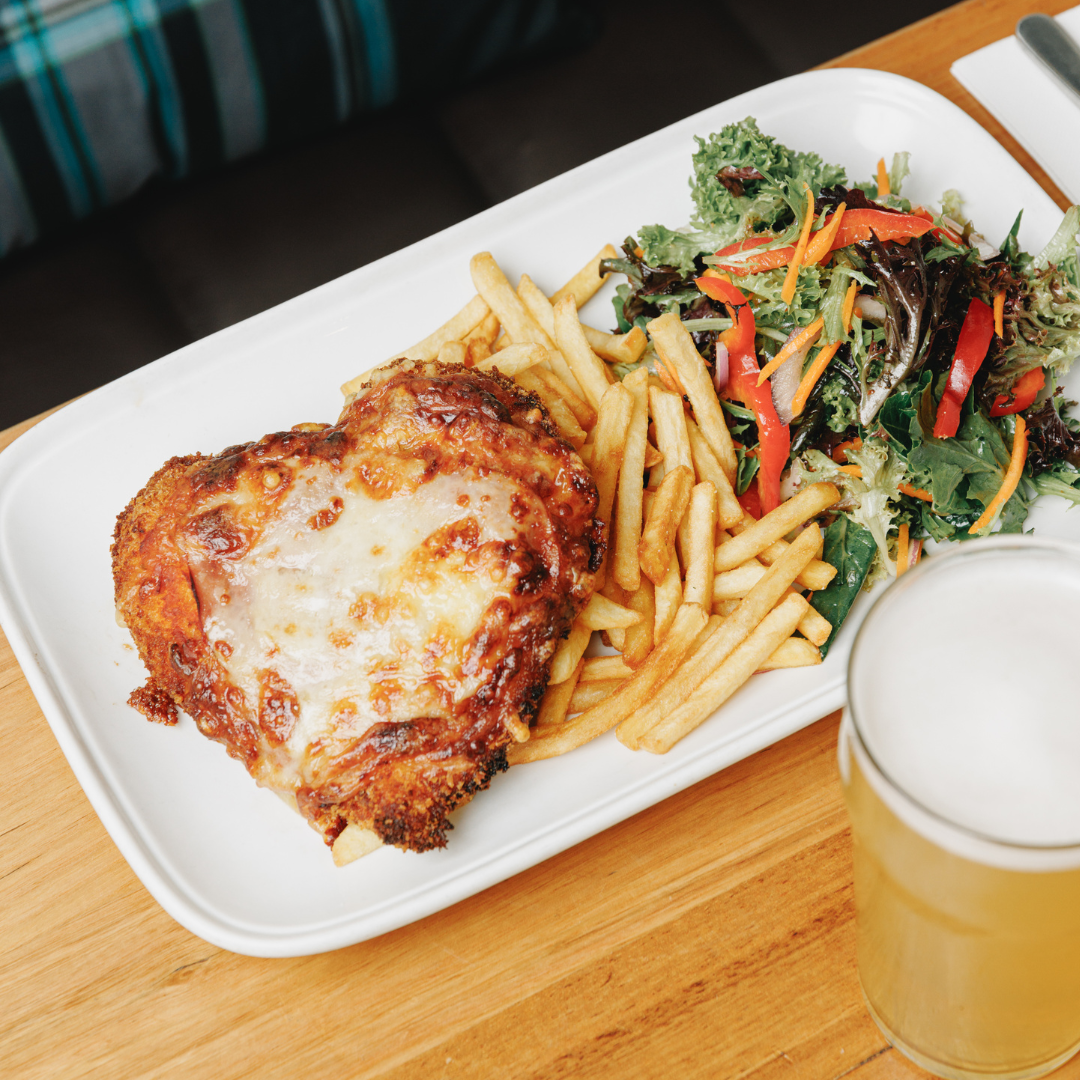 Classic chicken parma served as The Mint’s daily special in Melbourne, topped with Napoli sauce, melted cheese, and a side of chips and salad