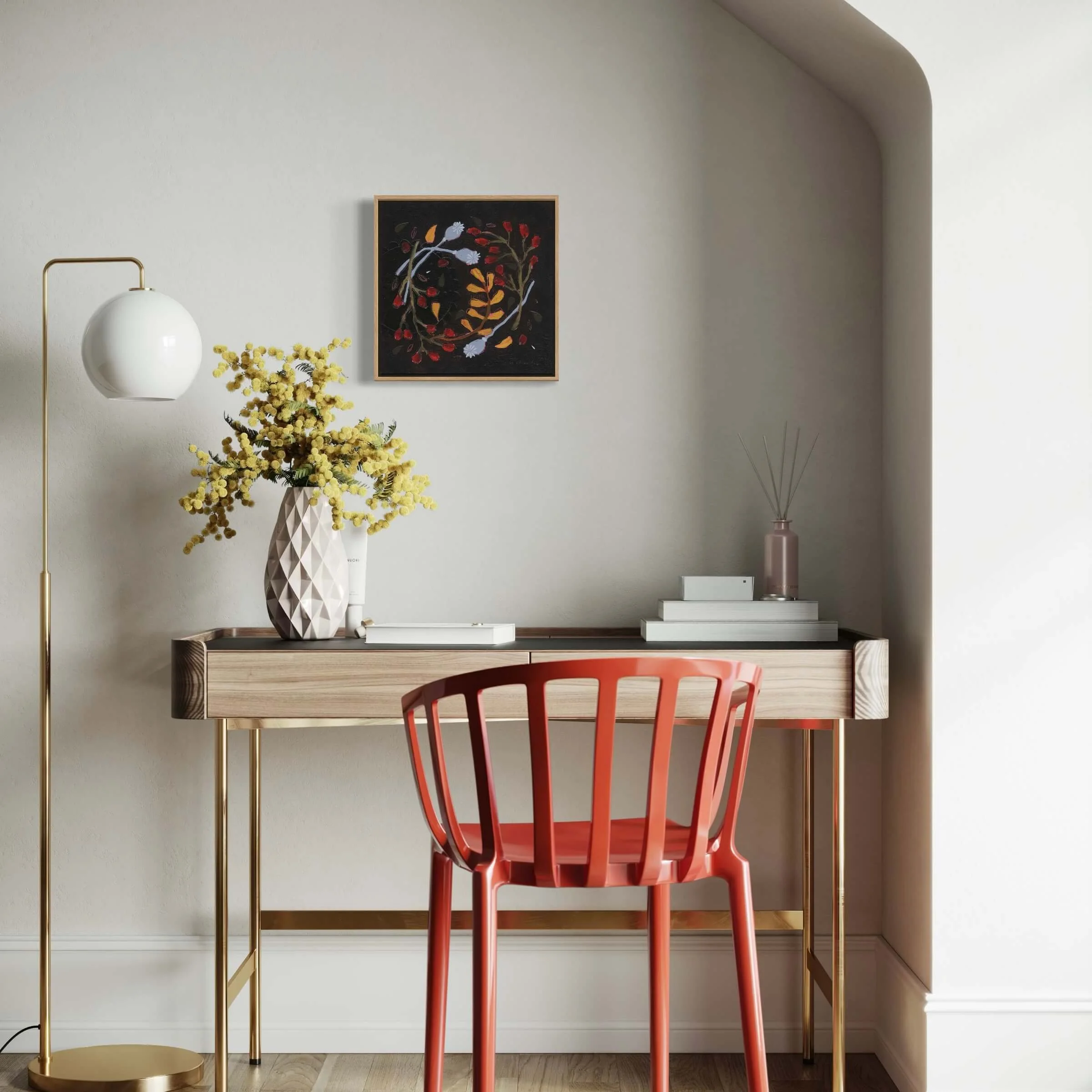 Framed original botanical painting Wilda by Ali Mackie Art hanging above an elegant desk setup featuring a coral red chair and yellow mimosa flowers.