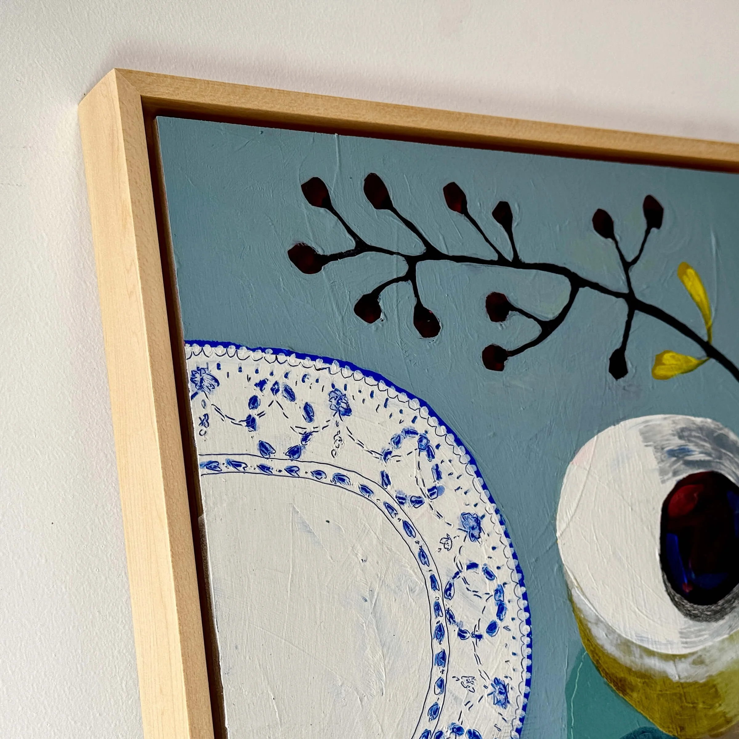 Close-up detail of Lets Sit Together original painting by Ali Mackie Art showing hand-painted blue ceramic patterns and wood frame.