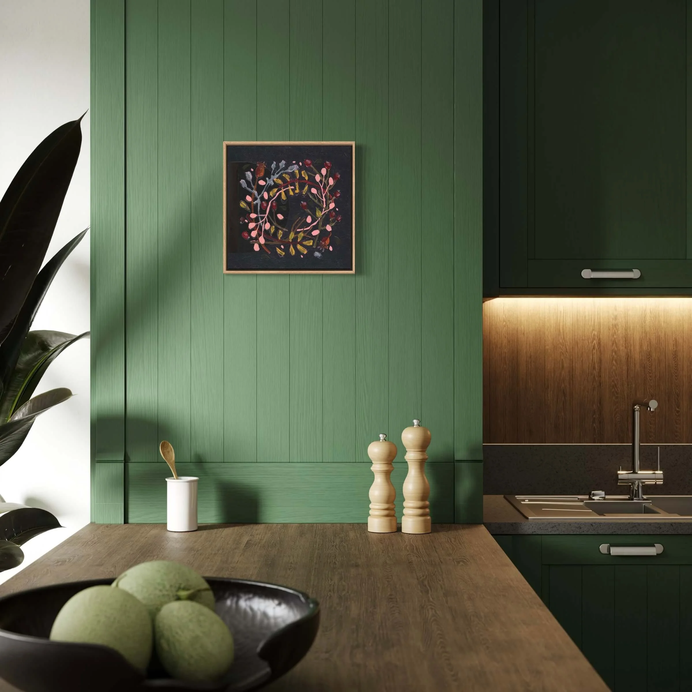 Framed Wallis botanical wreath art hanging on a sage green panelled wall in a modern kitchen interior.