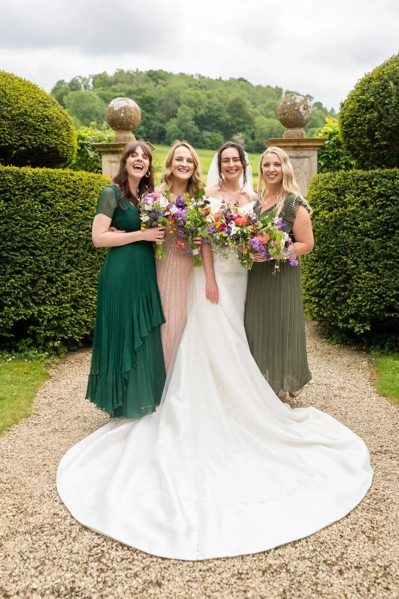 Smiling bride and bridesmaids with bouquets they made themselves