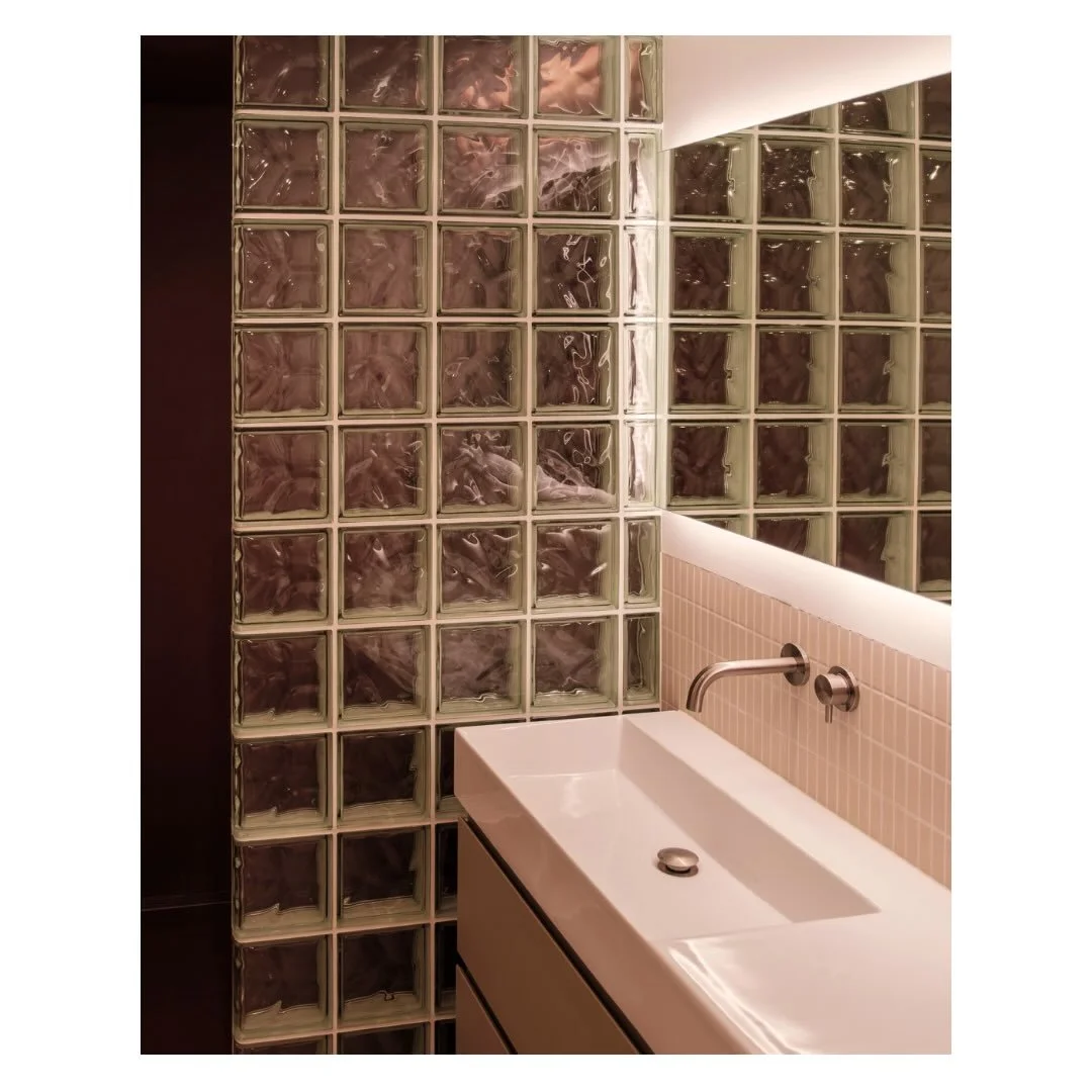 Bathroom details&hellip;
A combination of soft beige bathroom kitkat tiles, contrasted against a rust red shower &ldquo;box&rdquo;, with a glass brick shower wall acting as the mediating element.

Design by @studio___p3 
Photography by @justinreidros