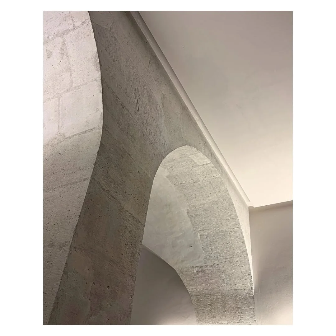 A gorgeous stone arch at the Mus&eacute;e Picasso, Paris. 

Raw stone meeting the plastered wall with almost no transition at all. The contrast and harmony between the two is where the beauty lives.

No colour. Just form doing exactly what it needs t