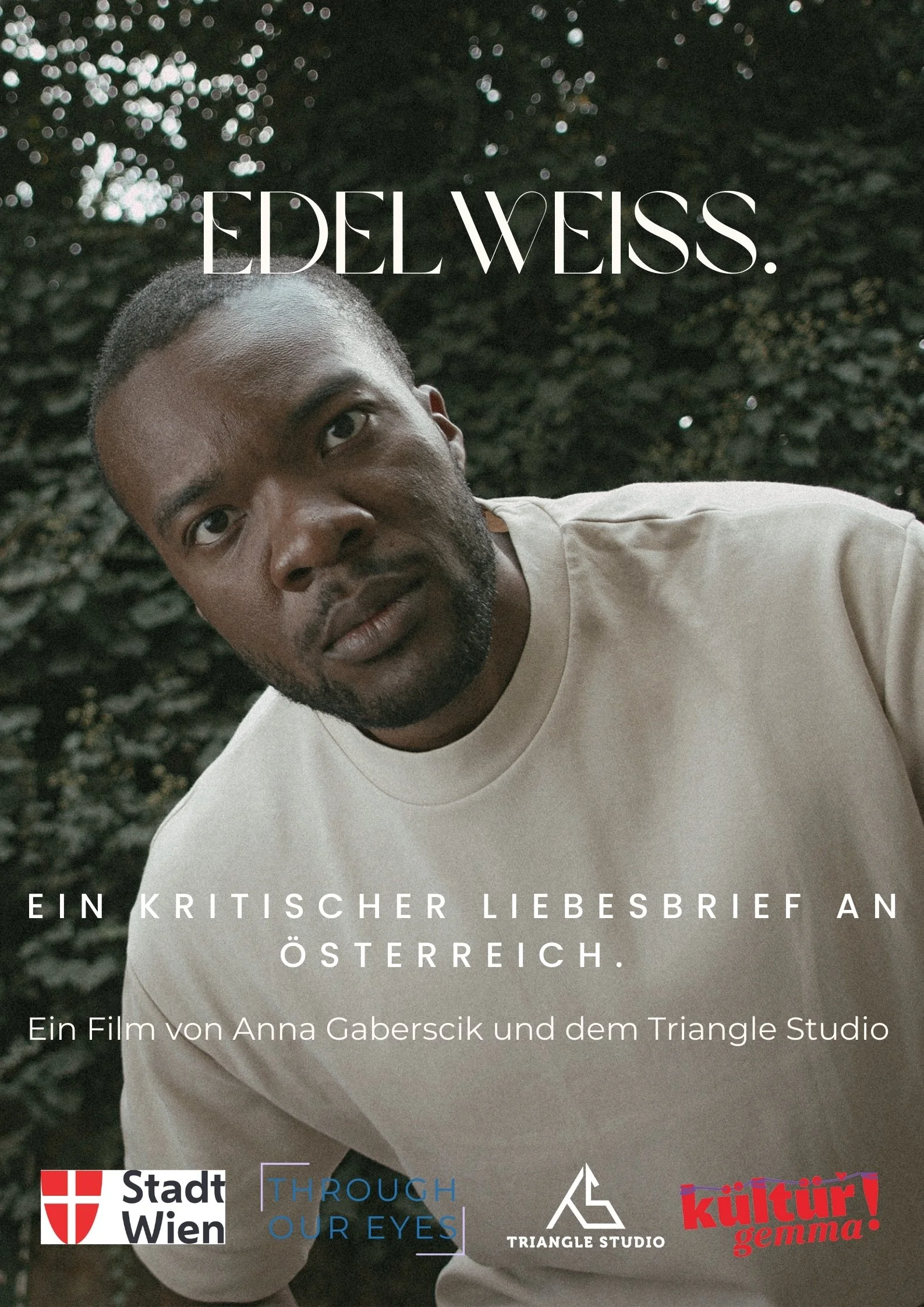 Porträt eines Mannes mit dunkler Haut, kurzen Haaren und Bart, der in die Kamera blickt, vor einem dunklen, grünen Hintergrund.