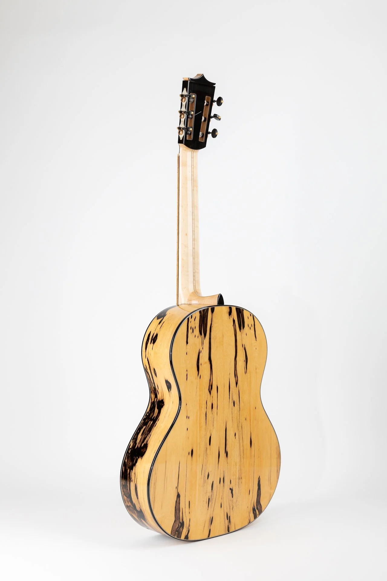 Eine akustische Gitarre mit einer speziellen Maserung auf dem Korpus, aufrecht stehend vor einem weißen Hintergrund.