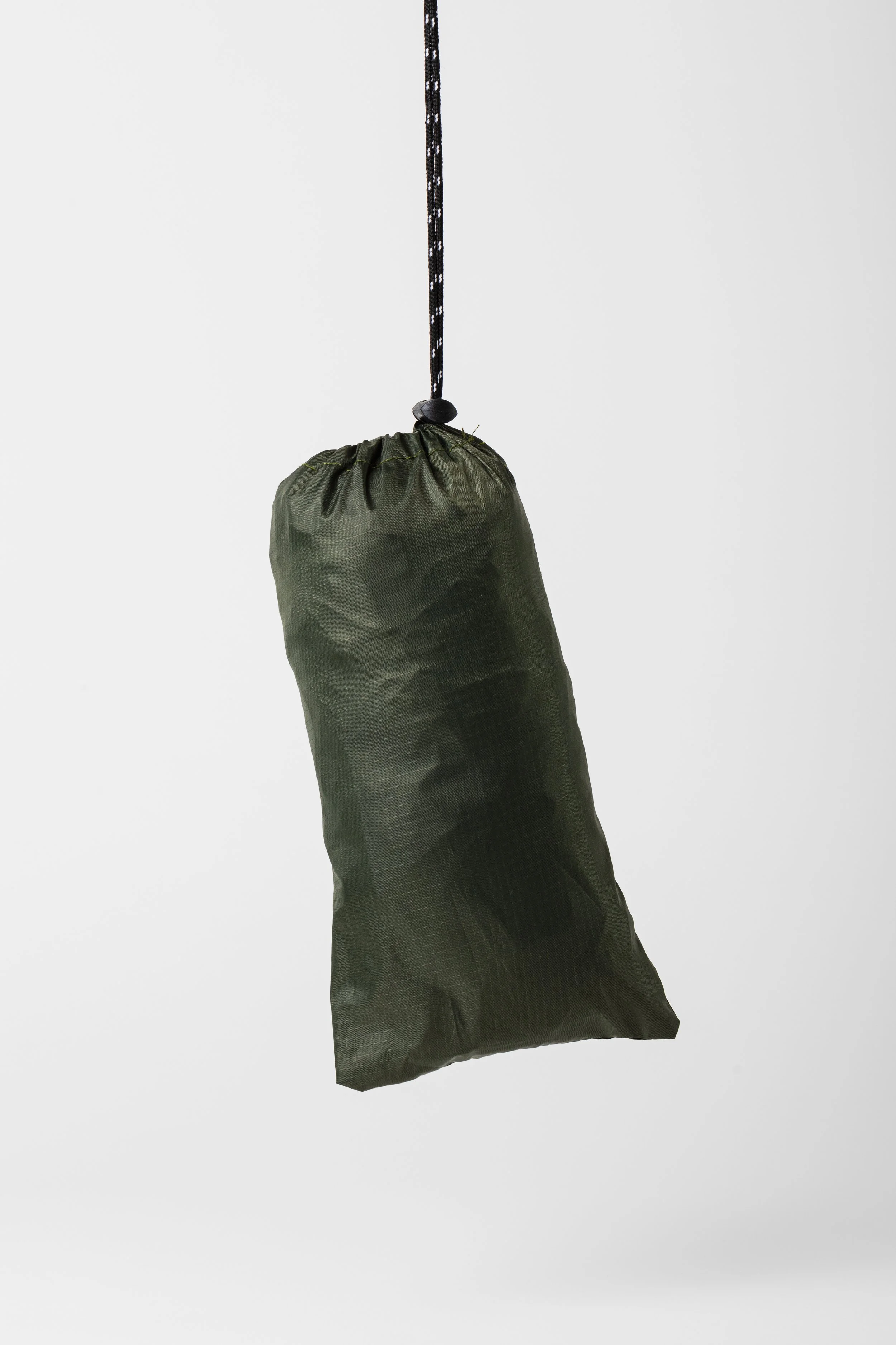 Ein grüne aufhängbare Tragetasche, vermutlich aus wasserdichtem Material, mit einem schwarzen Kordelzug und schwarzen Kunststoffkeilen.