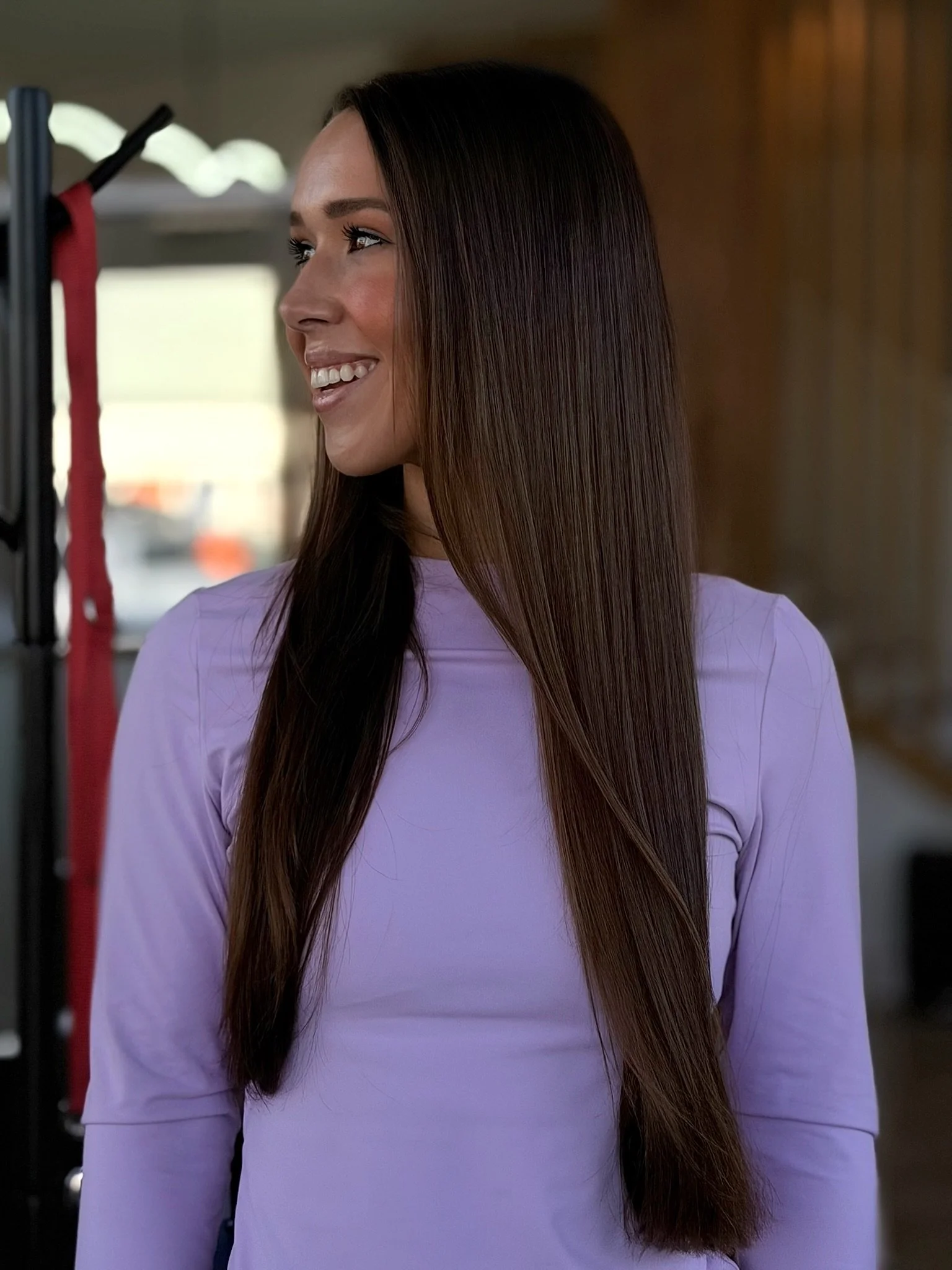 Long, straight dark brown hair worn over a lavender top in the Beauty Culture salon.