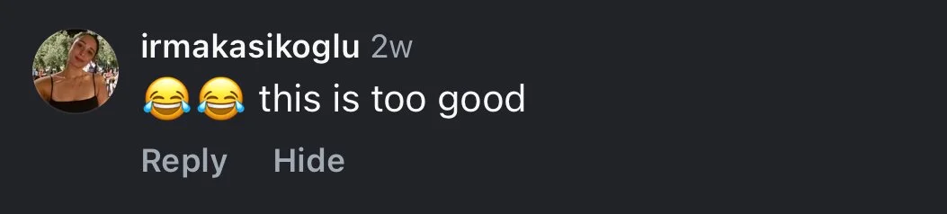 A person with braided hair and glasses standing in front of a church.