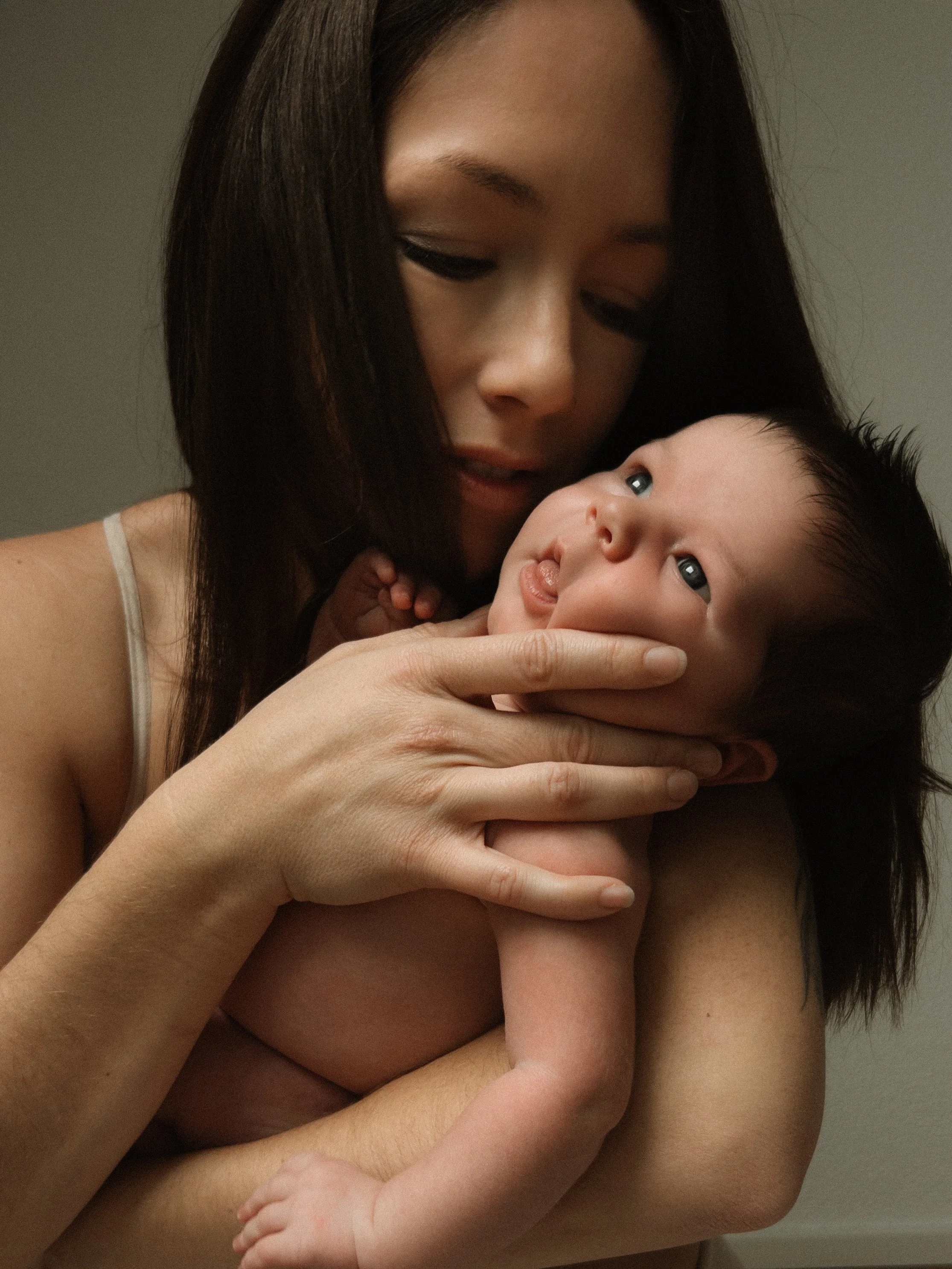 mother kissing her newborn baby