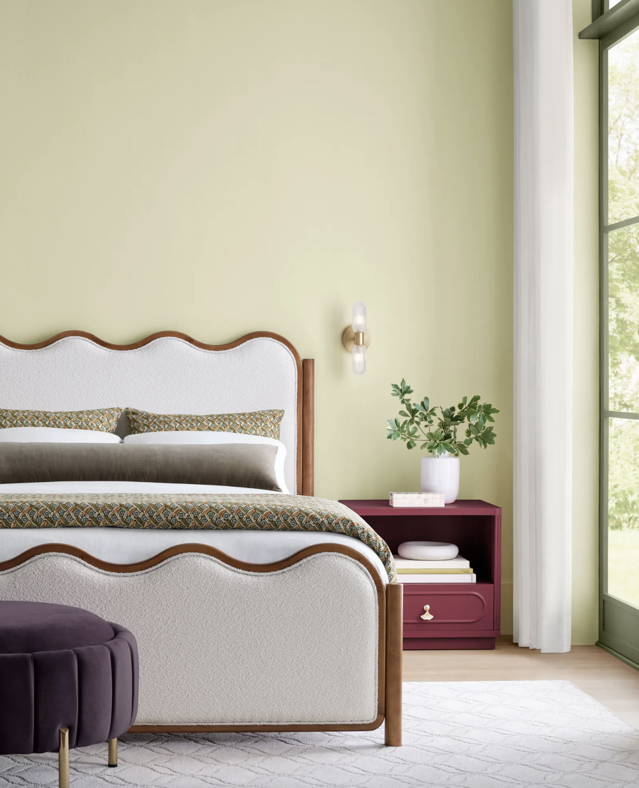Sherwin Williams Celery in a bedroom with a wavy, upholstered bed frame.