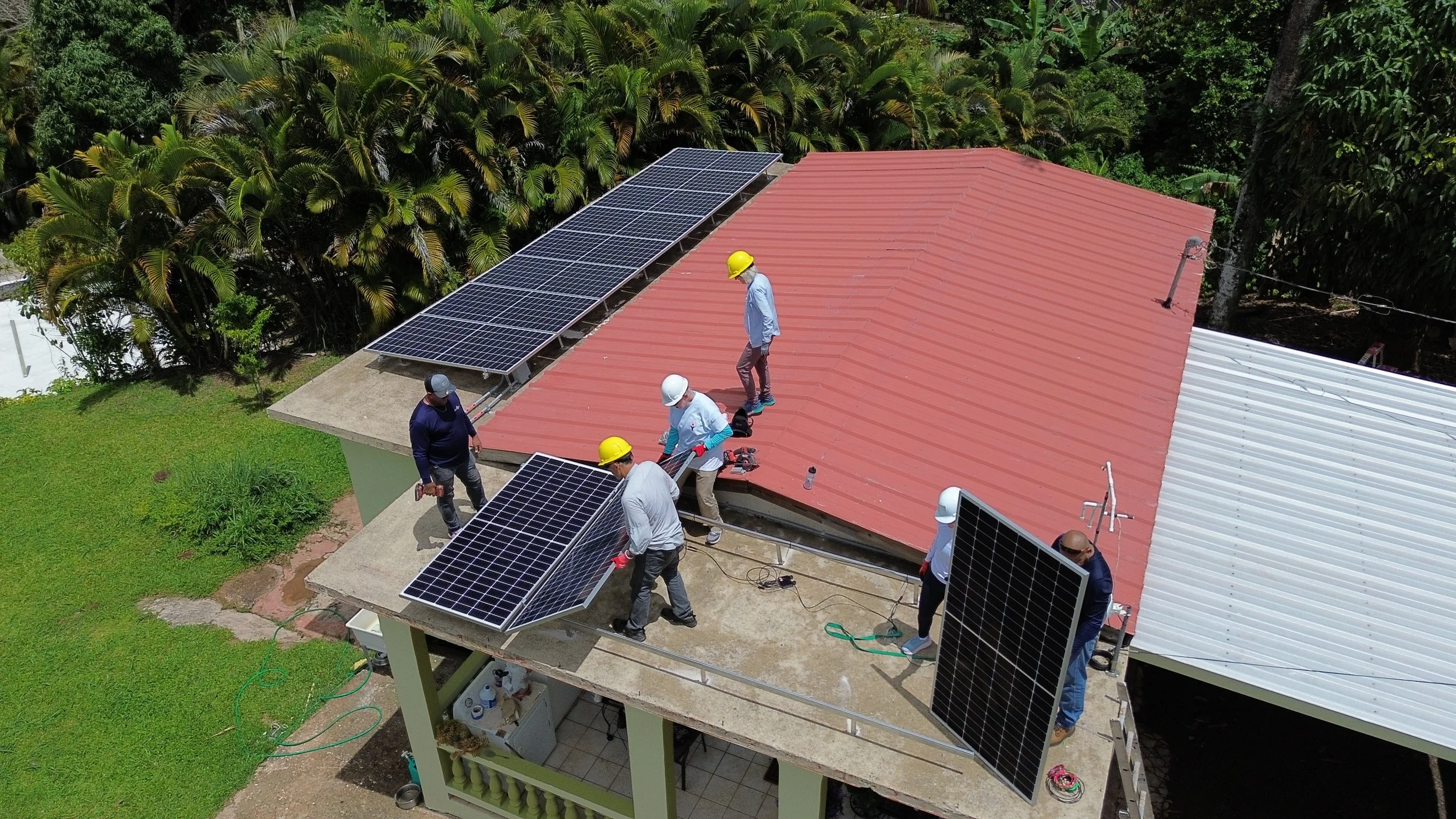 Princeton delegates help carry and place panels on roof.