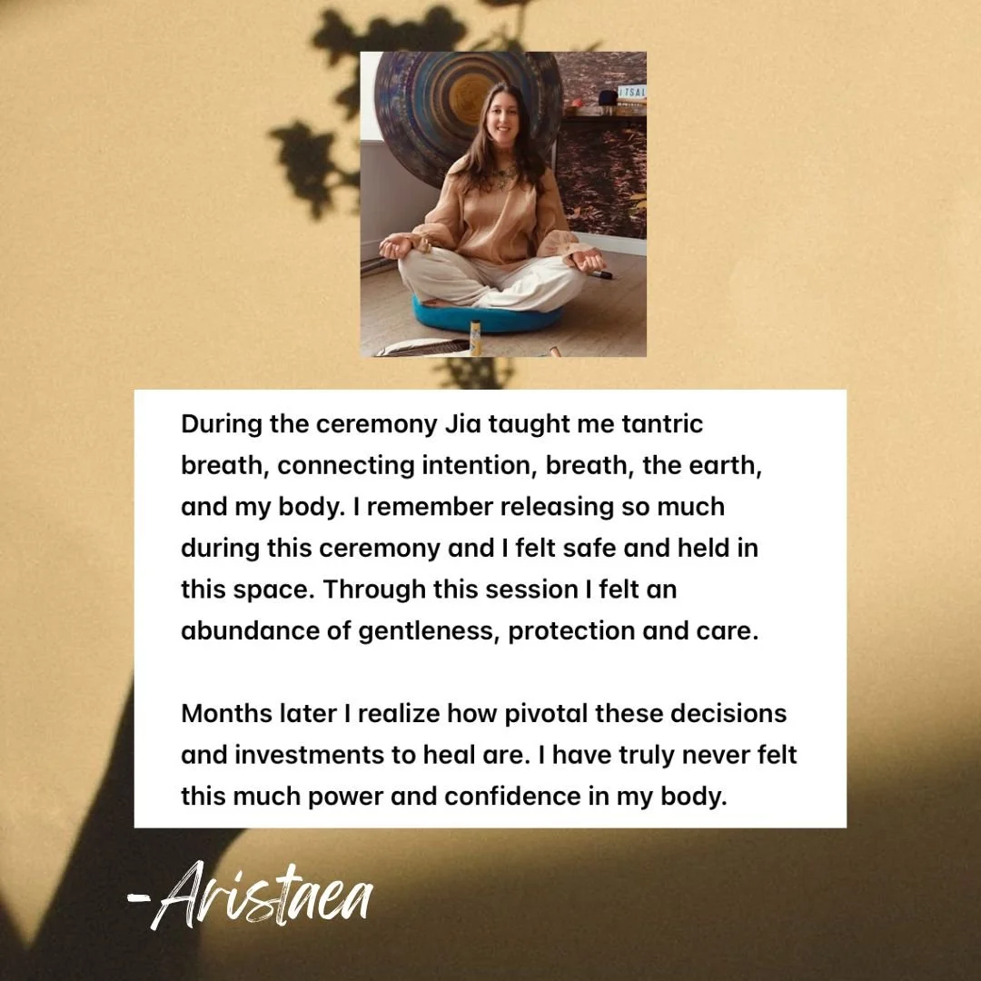 A woman sitting cross-legged on a cushion, meditating with her eyes closed. Behind her, there is artwork featuring a circular pattern and a brick wall. The scene appears to be in a cozy indoor space with a warm, peaceful ambiance. Below her photo is